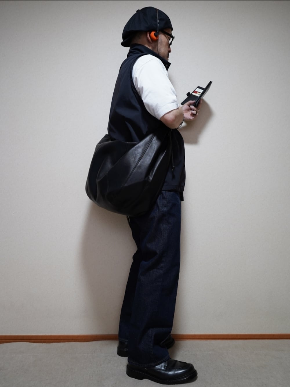 ブラック系のシューズ、ブルー系のデニムパンツ、ホワイト系のTシャツ/カットソーを着用したメンズの秋コーディネートの5枚目の写真