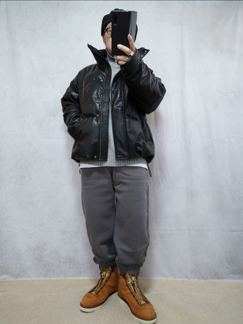 ブラウン系のブーツ、グレー系のスウェットパンツ、グレー系のニット/セーターを着用したメンズの冬コーディネートの4枚目の写真