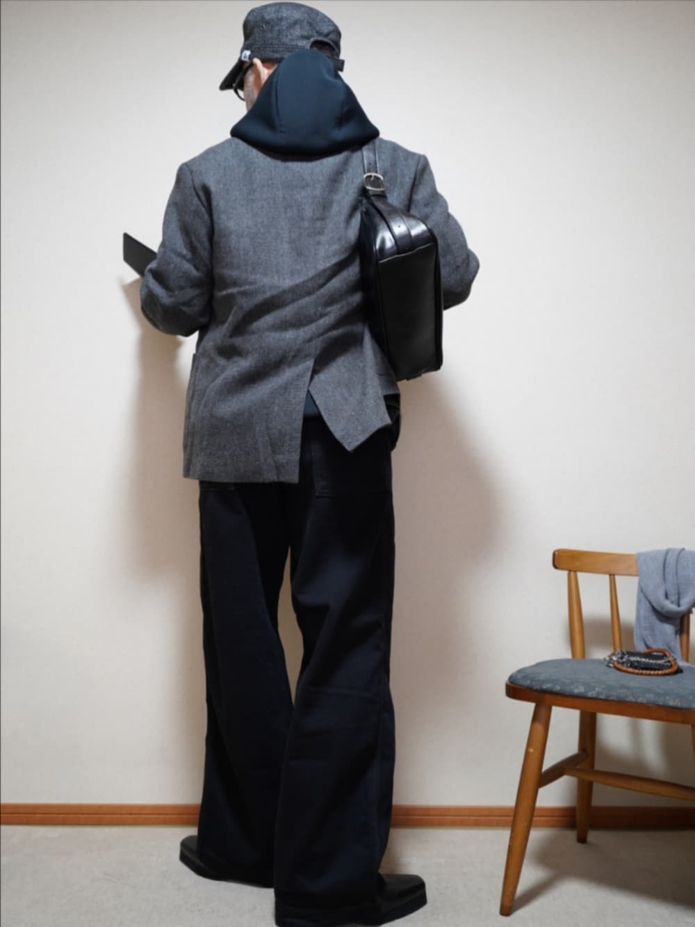 ブラック系のブーツ、ブラック系のデニムパンツ、ブラック系のショルダーバッグを着用したメンズの春コーディネートの4枚目の写真