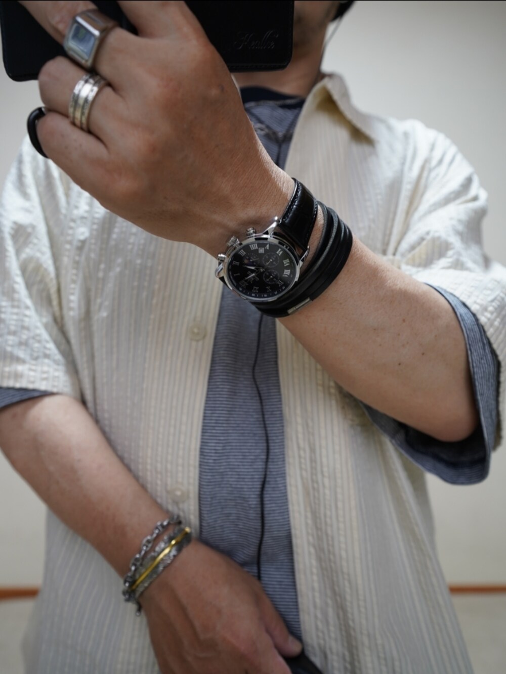 ブラック系のシューズ、ブルー系のデニムパンツ、ブラック系のショルダーバッグを着用したメンズの夏コーディネートの2枚目の写真