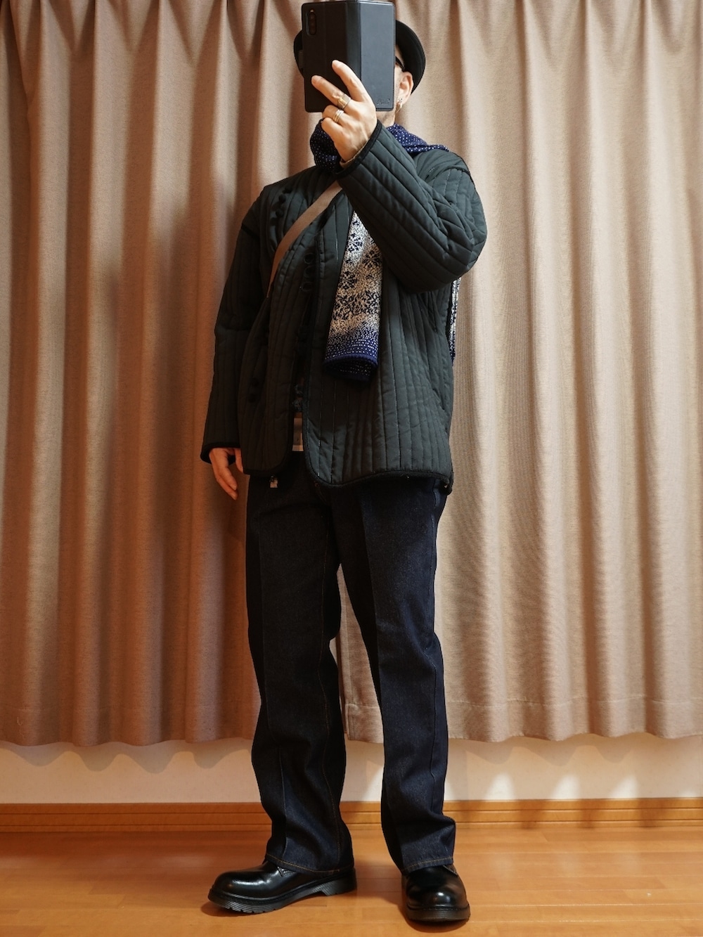 ブラック系のシューズ、ブルー系のデニムパンツ、ブラック系のミリタリージャケットを着用したメンズの秋コーディネートの3枚目の写真