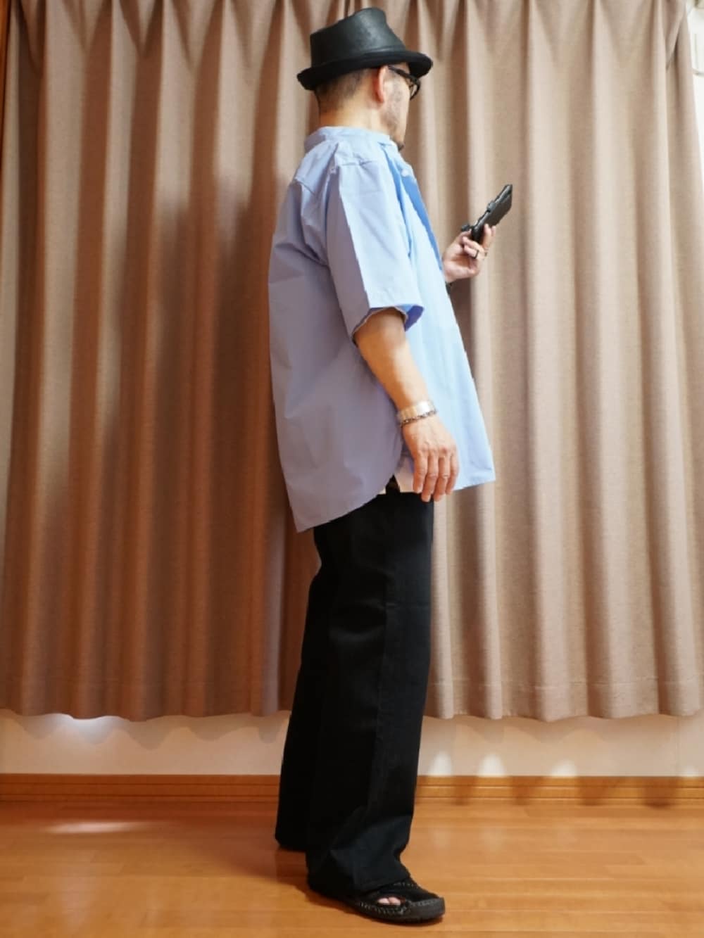 ブラック系のサンダル、グレー系のデニムパンツ、ホワイト系のタンクトップを着用したメンズの夏コーディネートの4枚目の写真