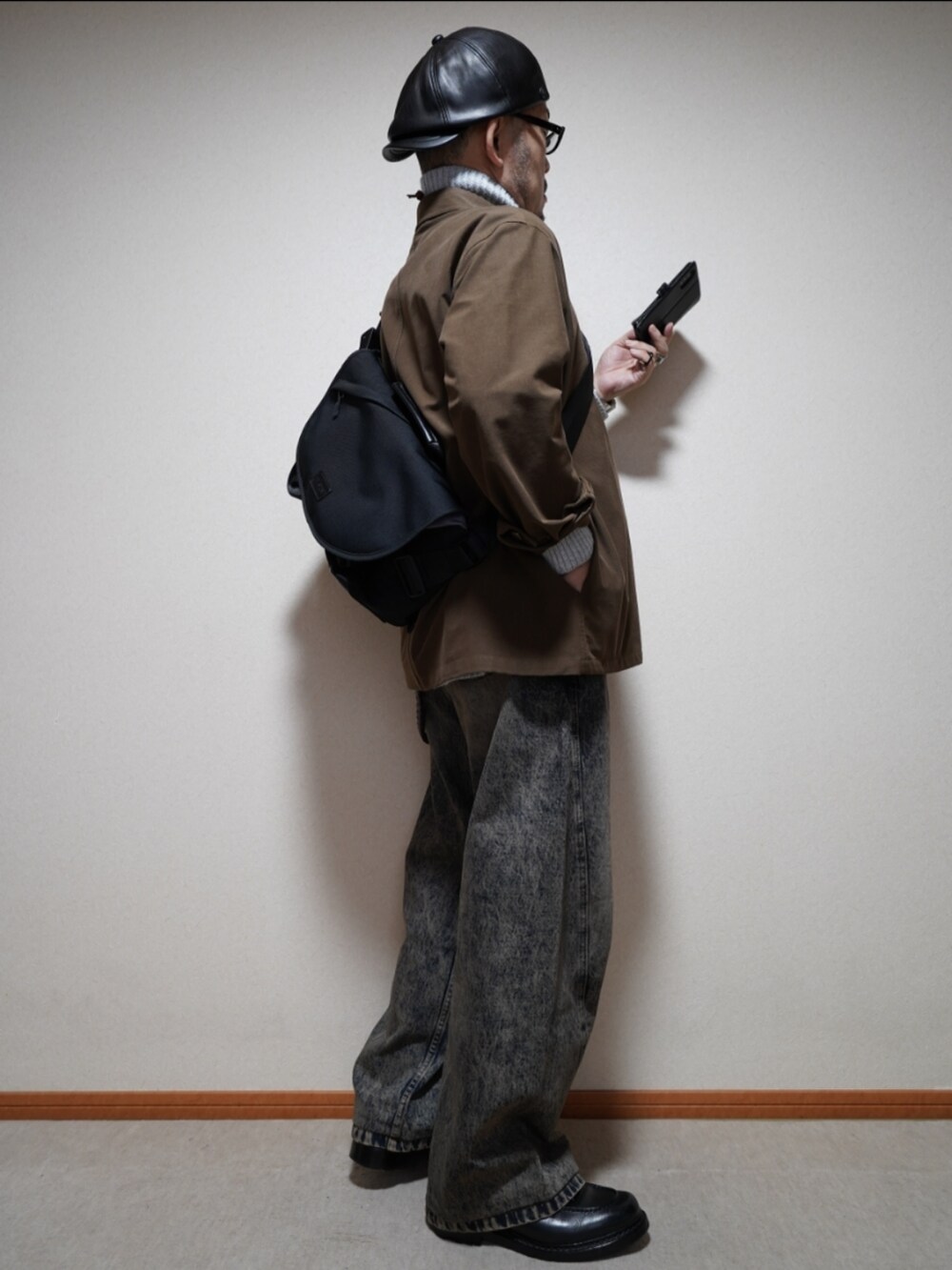 ブラック系のシューズ、ブルー系のデニムパンツ、グレー系のトップスを着用したメンズの冬コーディネートの4枚目の写真