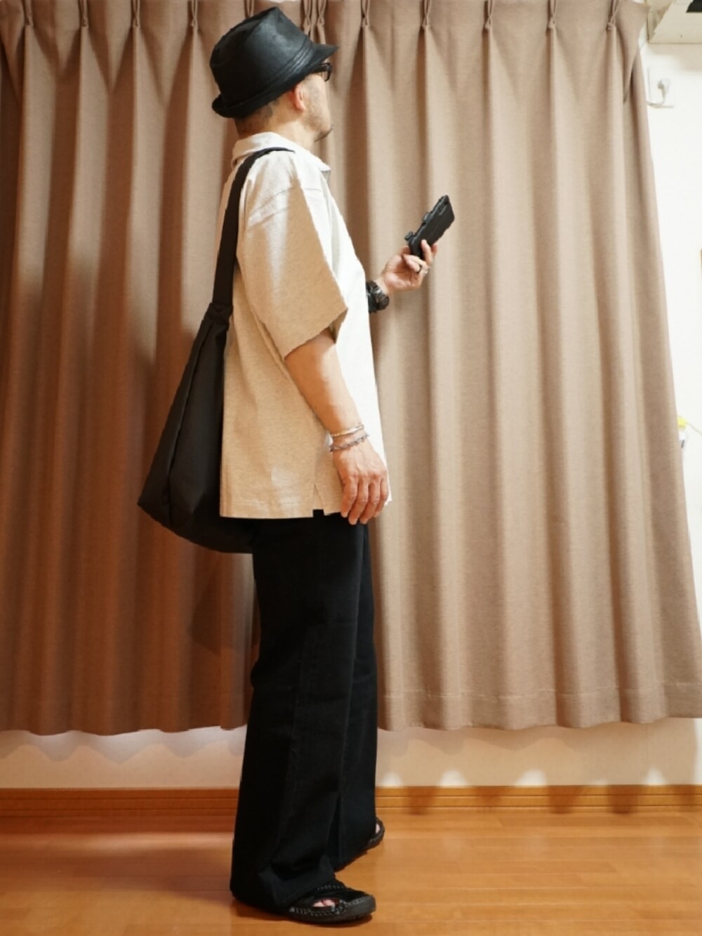 ブラック系のサンダル、グレー系のデニムパンツ、ベージュ系のTシャツ/カットソーを着用したメンズの夏コーディネートの4枚目の写真