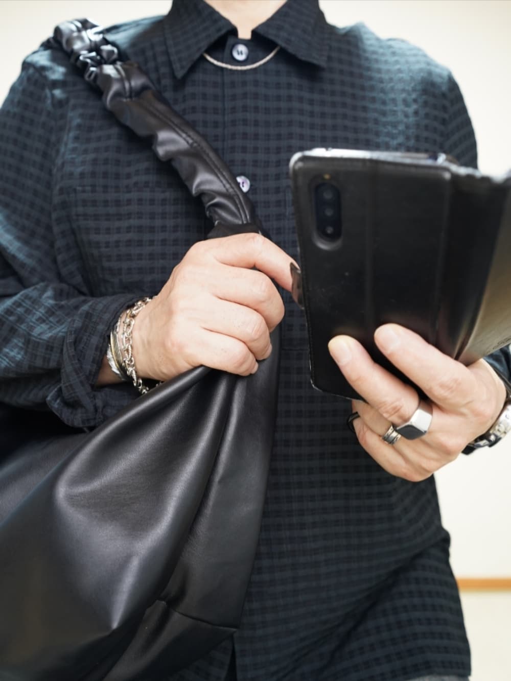 ブラック系のシューズ、ブルー系のデニムパンツ、ブラック系のショルダーバッグを着用したメンズの春コーディネートの3枚目の写真