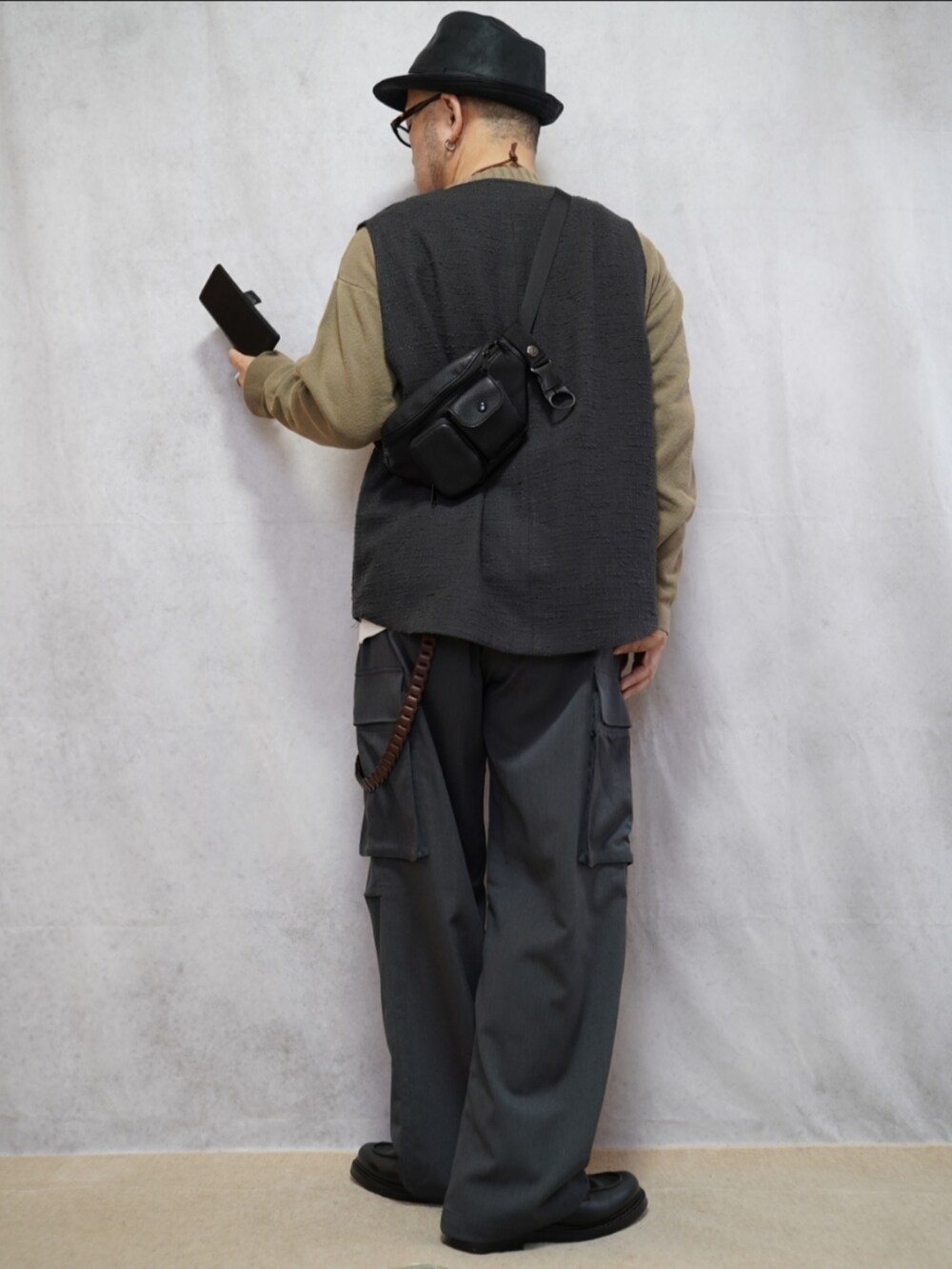 ブラック系のシューズ、グレー系のカーゴパンツ、ベージュ系のニット/セーターを着用したメンズの春コーディネートの3枚目の写真