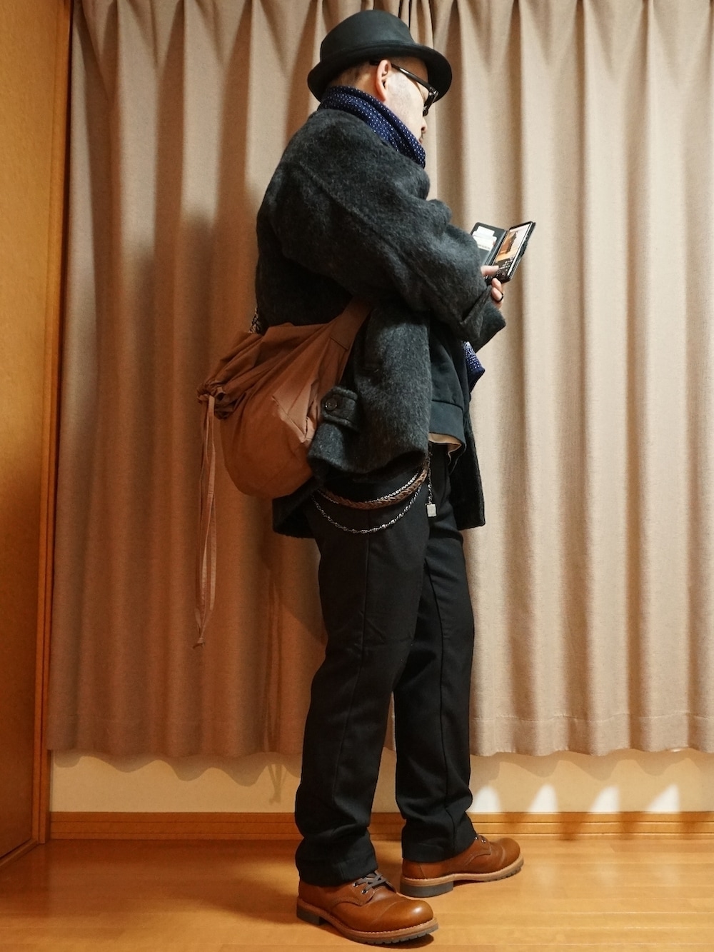 ブラウン系のブーツ、ブラック系のスラックス、ブラック系のトップスを着用したメンズの秋コーディネートの4枚目の写真