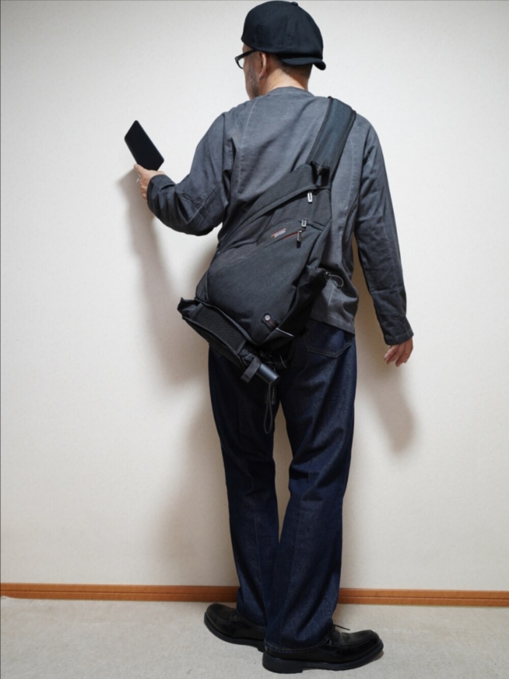 ブラック系のシューズ、ブルー系のデニムパンツ、グレー系のTシャツ/カットソーを着用したメンズの秋コーディネートの4枚目の写真