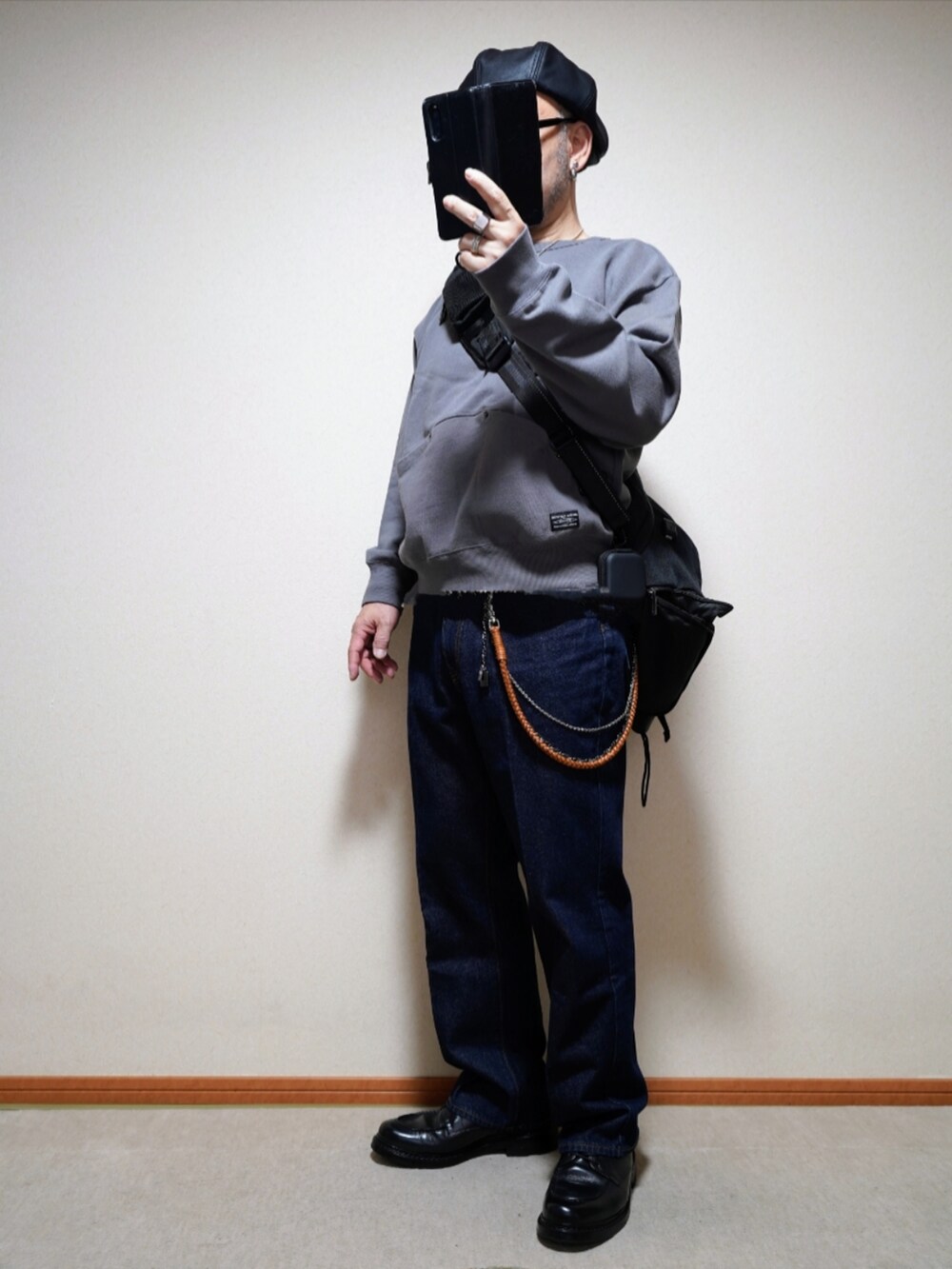 ブラック系のシューズ、ブルー系のデニムパンツ、グレー系のトップスを着用したメンズの春コーディネートの2枚目の写真