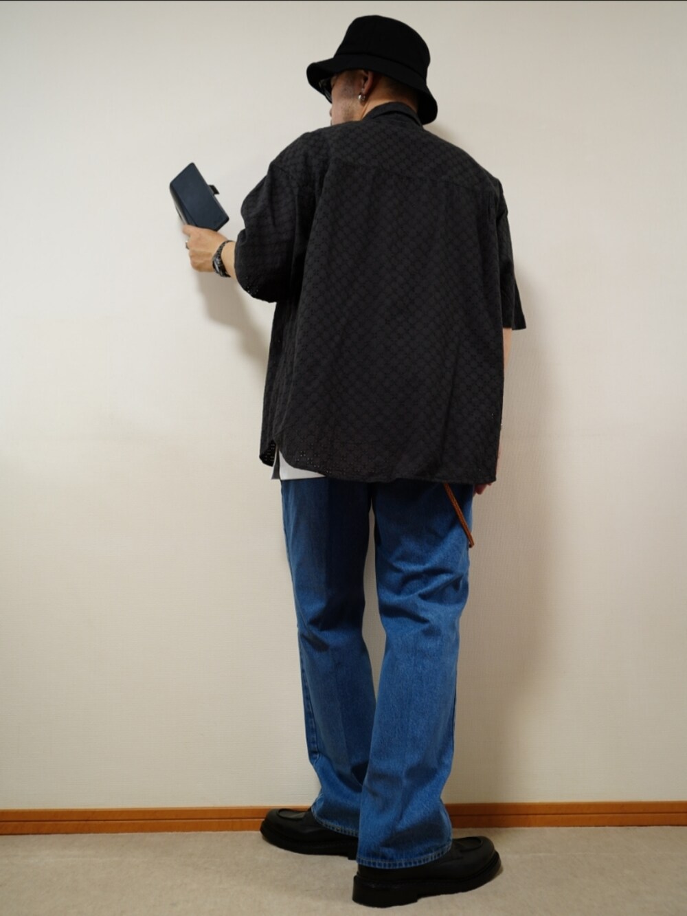 ブラック系のシューズ、ブルー系のデニムパンツ、ホワイト系のタンクトップを着用したメンズの夏コーディネートの3枚目の写真