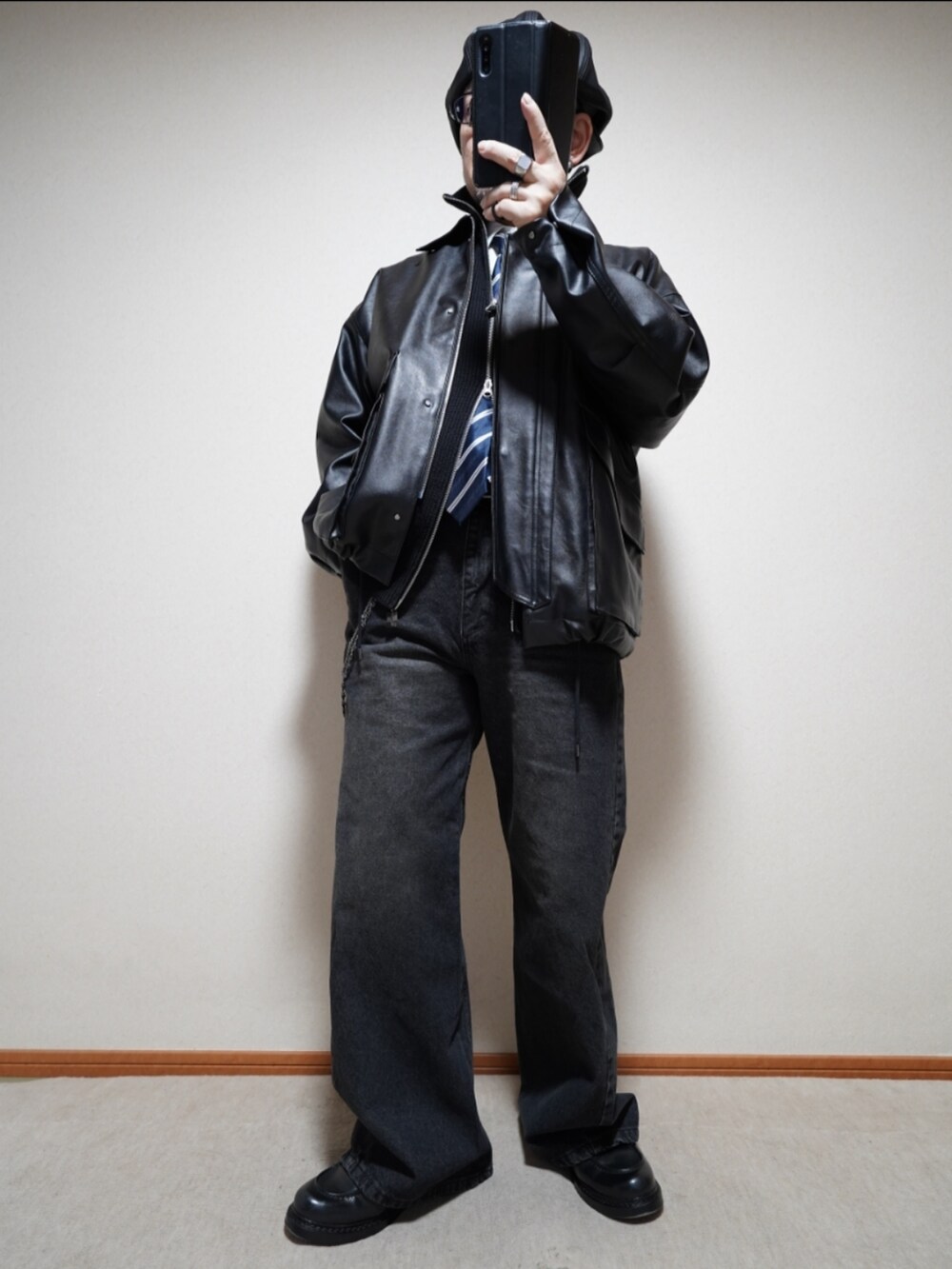 ブラック系のシューズ、ブラック系のデニムパンツ、ブラック系のジャケット/アウターを着用したメンズの冬コーディネートの2枚目の写真