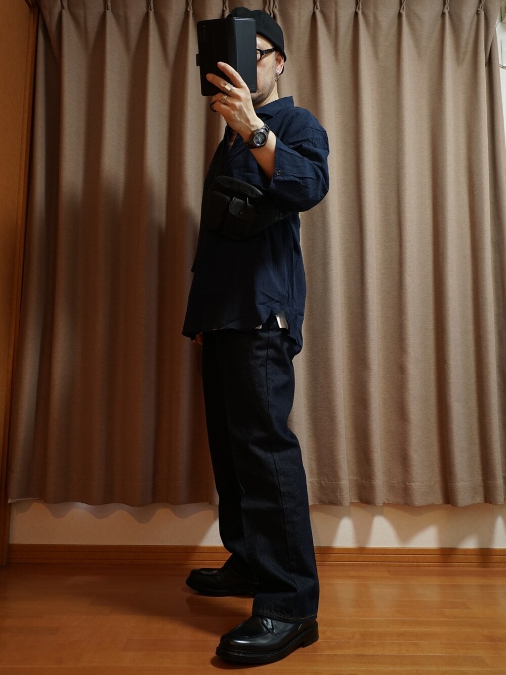 ブラック系のシューズ、ブルー系のデニムパンツ、ホワイト系のタンクトップを着用したメンズの夏コーディネートの2枚目の写真