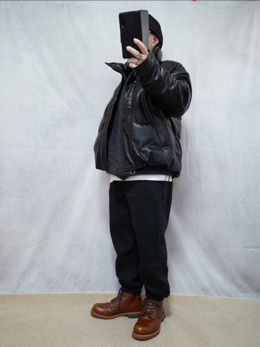 ブラウン系のブーツ、ブラック系のスウェットパンツ、ブラック系のダウンジャケット/コートを着用したメンズの冬コーディネートの2枚目の写真