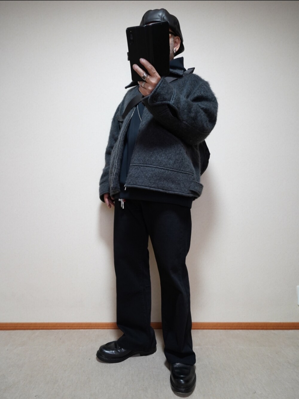 ブラック系のシューズ、グレー系のデニムパンツ、ブラック系のパーカーを着用したメンズの冬コーディネートの2枚目の写真