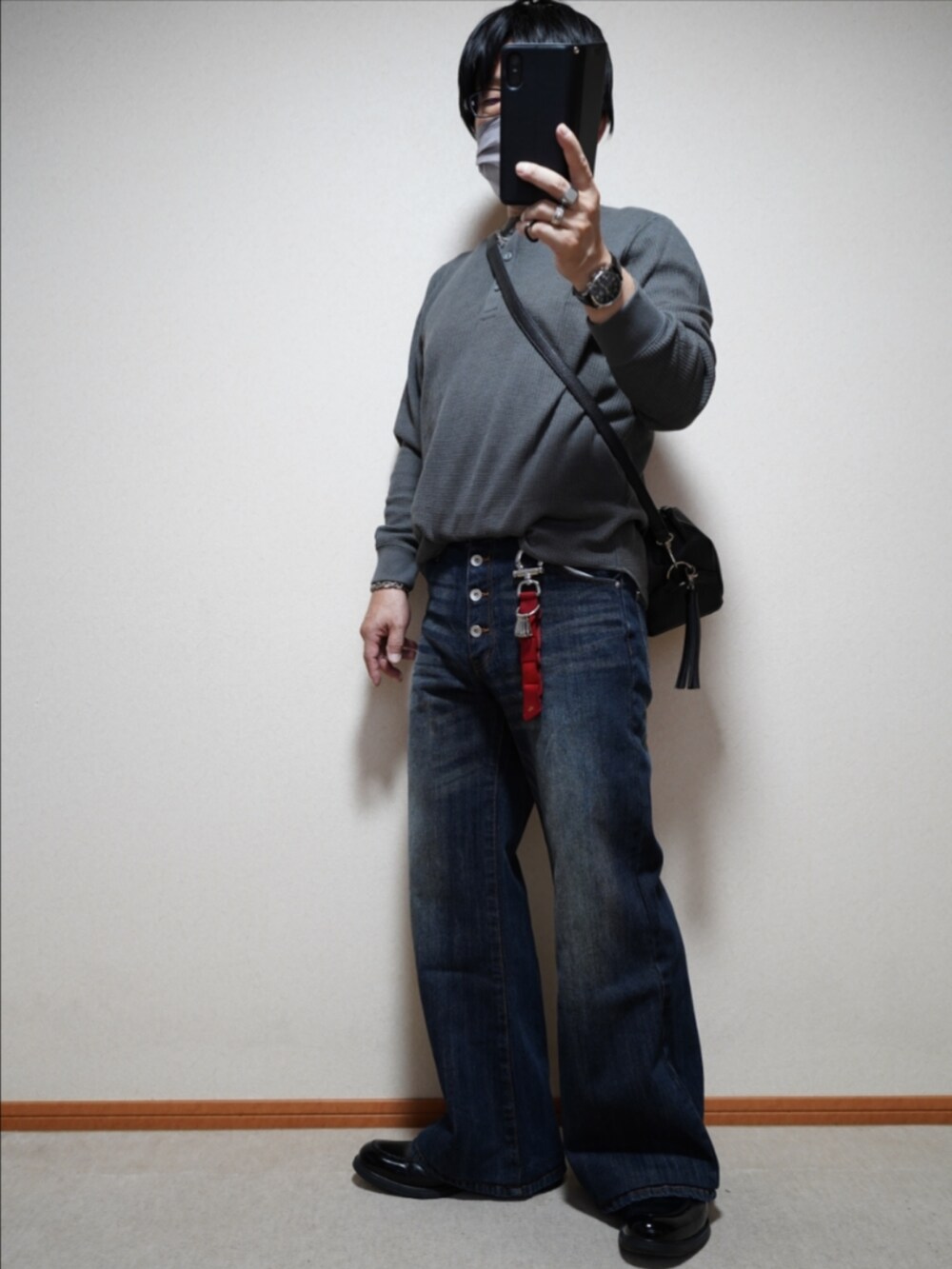 ブラック系のシューズ、ブルー系のデニムパンツ、ブラック系のショルダーバッグを着用したメンズの秋コーディネートの2枚目の写真