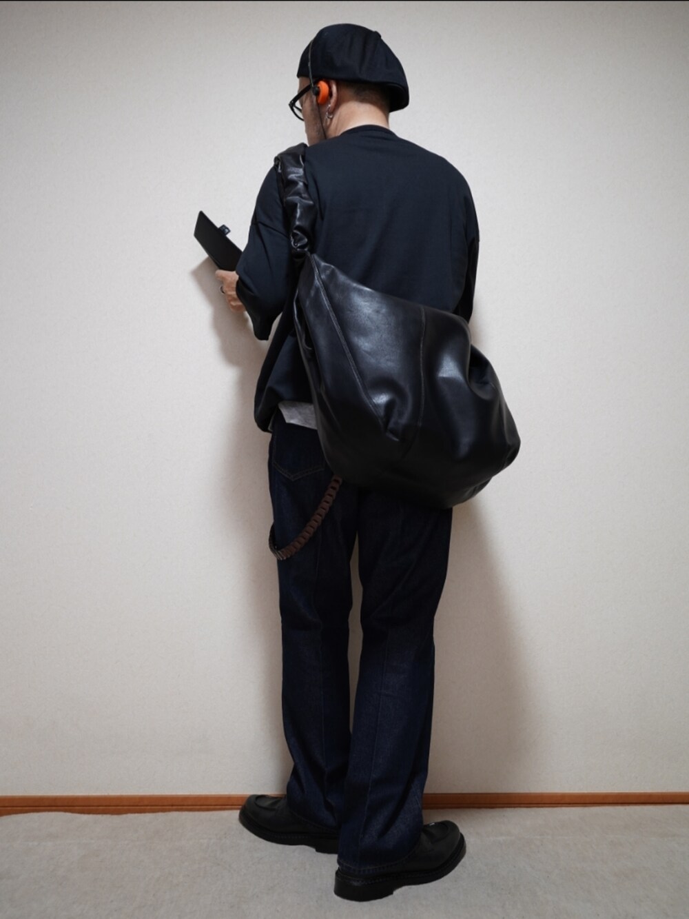 ブラック系のシューズ、ブルー系のデニムパンツ、ブラック系のTシャツ/カットソーを着用したメンズの夏コーディネートの3枚目の写真
