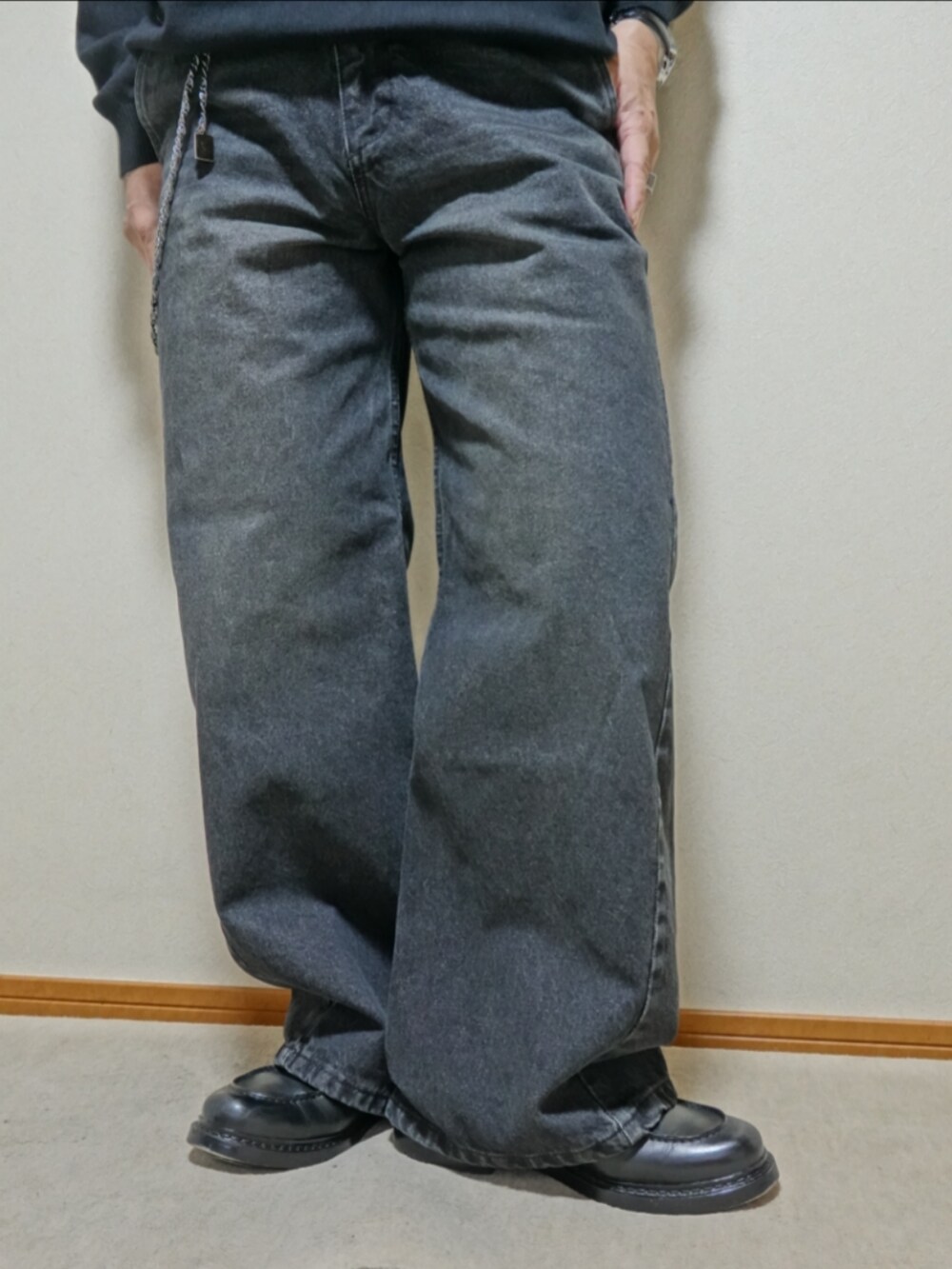 ブラック系のシューズ、ブラック系のデニムパンツ、ブラック系のニット/セーターを着用したメンズの春コーディネートの5枚目の写真