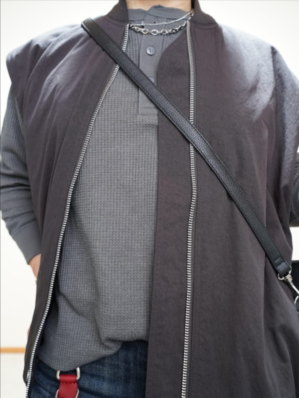 ブラック系のシューズ、ブルー系のデニムパンツ、ブラック系のショルダーバッグを着用したメンズの秋コーディネートの3枚目の写真