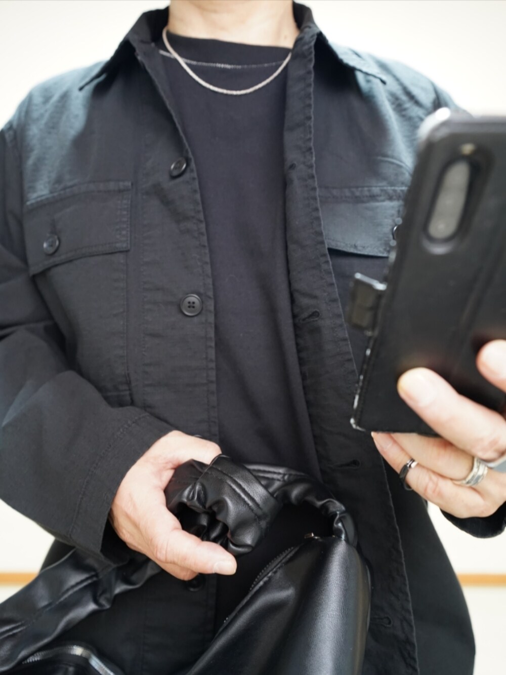 ブラック系のシューズ、ブルー系のデニムパンツ、ブラック系のショルダーバッグを着用したメンズの春コーディネートの3枚目の写真