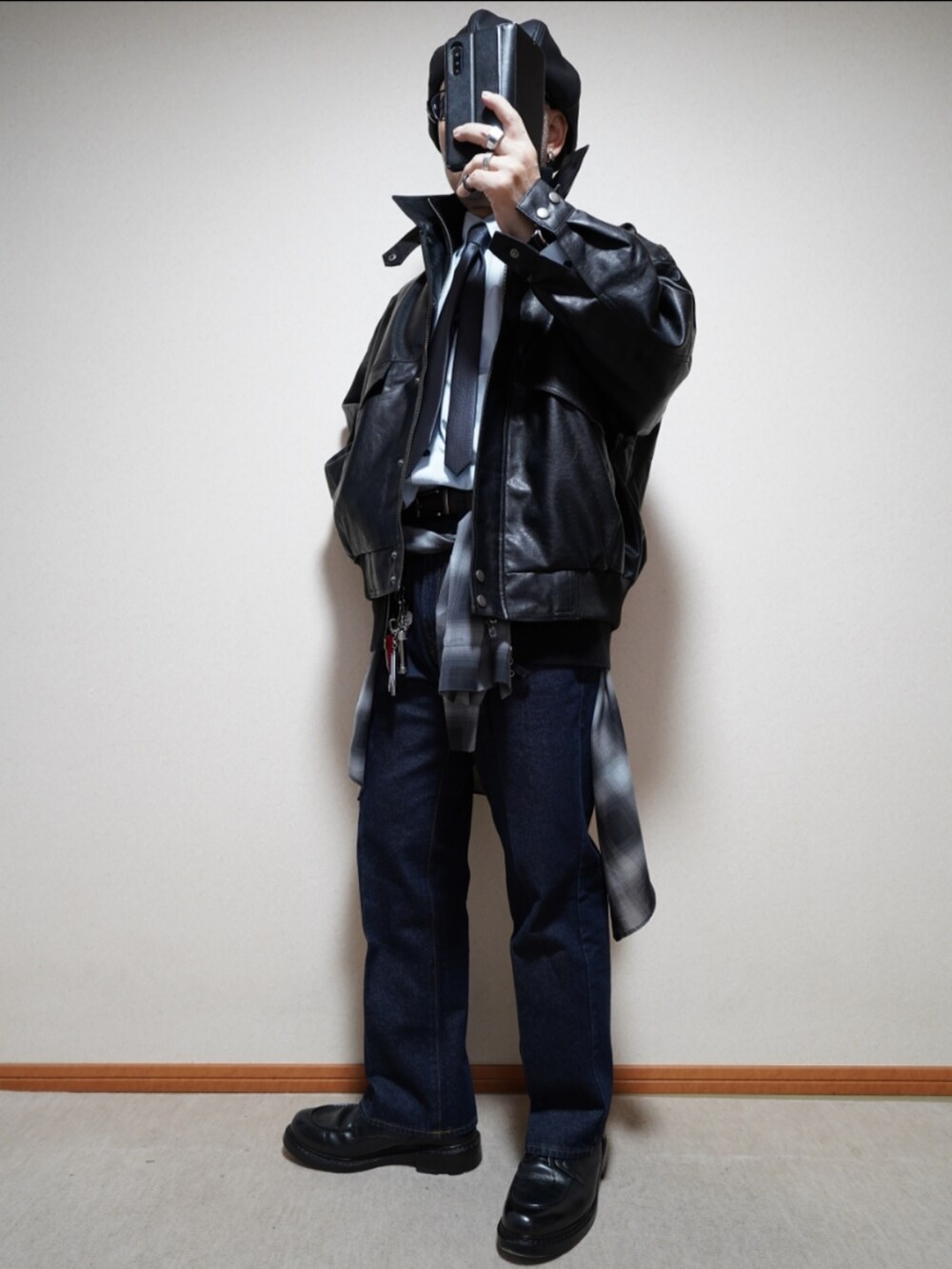 ブラック系のシューズ、ブルー系のデニムパンツ、ブラック系のシャツ/ブラウスを着用したメンズの冬コーディネートの2枚目の写真