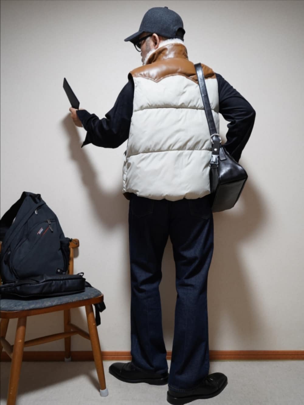 ブルー系のデニムパンツ、ブラック系のシャツ/ブラウス、その他のダウンベストを着用したメンズの秋コーディネートの3枚目の写真