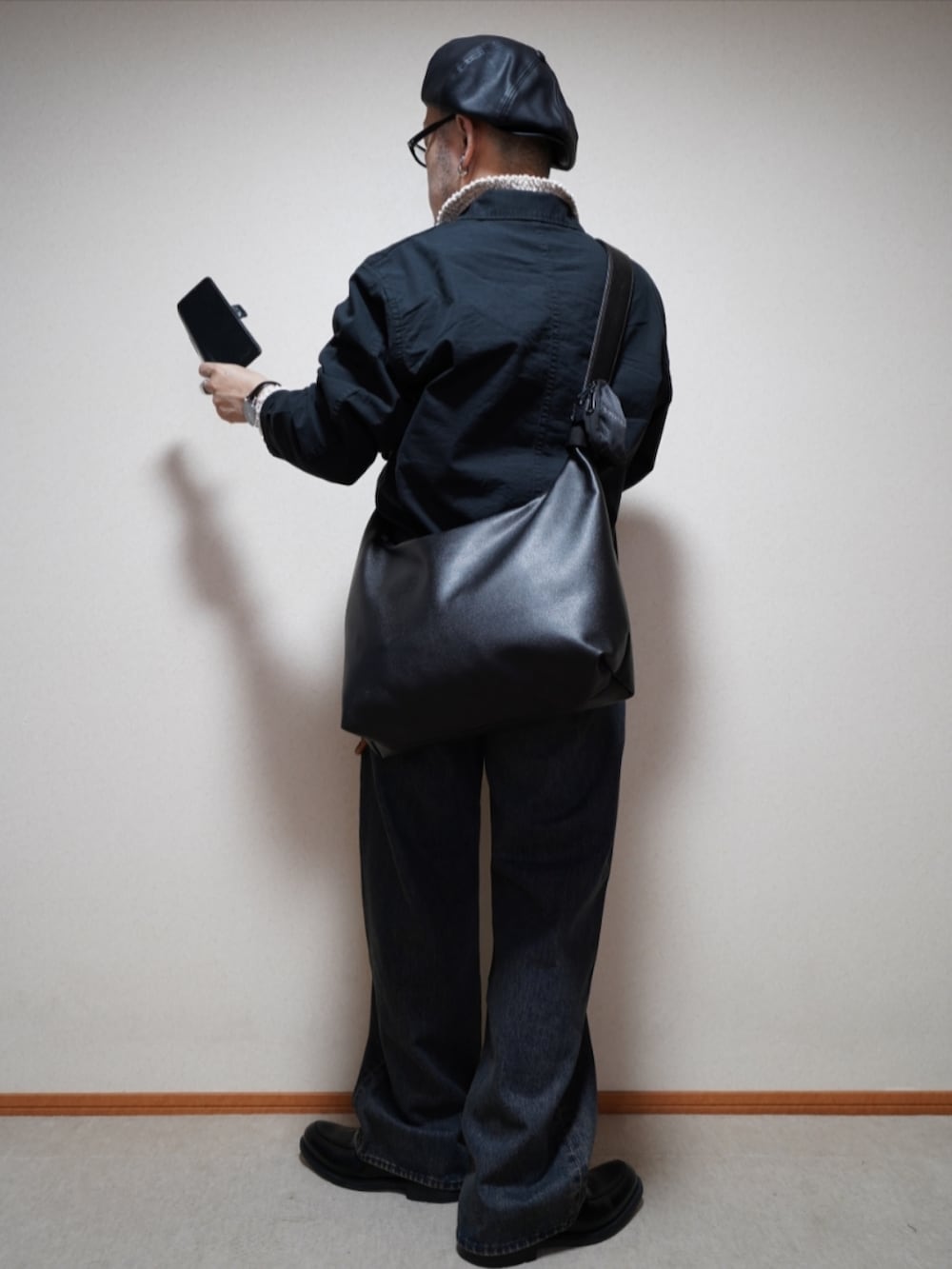 ブラック系のシューズ、ブルー系のデニムパンツ、ブラック系のシャツ/ブラウスを着用したメンズの春コーディネートの3枚目の写真