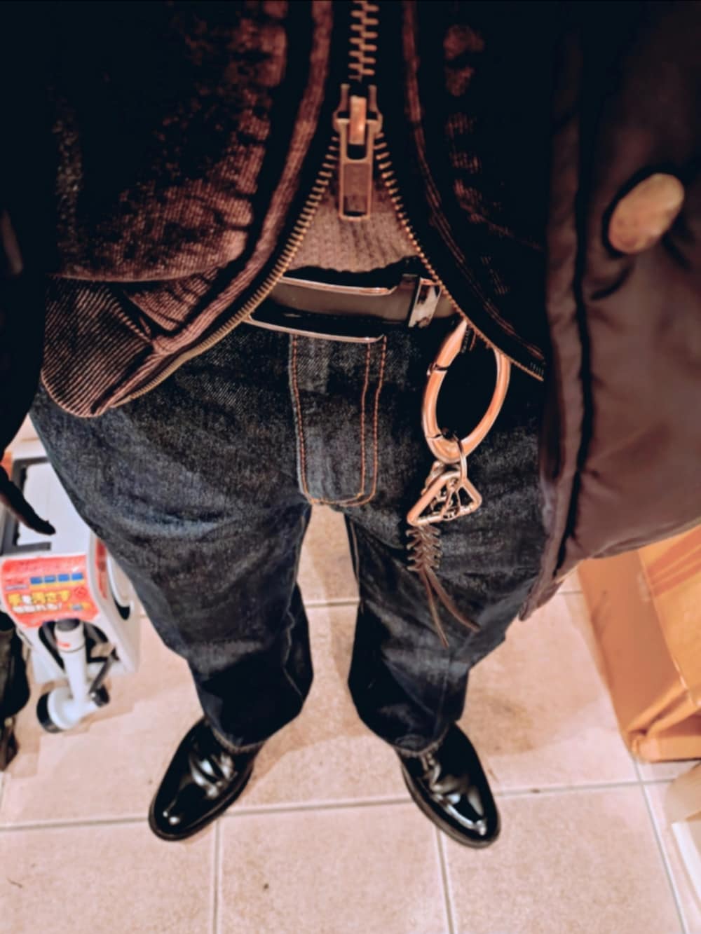 ブラック系のシューズ、ブルー系のデニムパンツ、ブラック系のパーカーを着用したメンズの春コーディネートの3枚目の写真