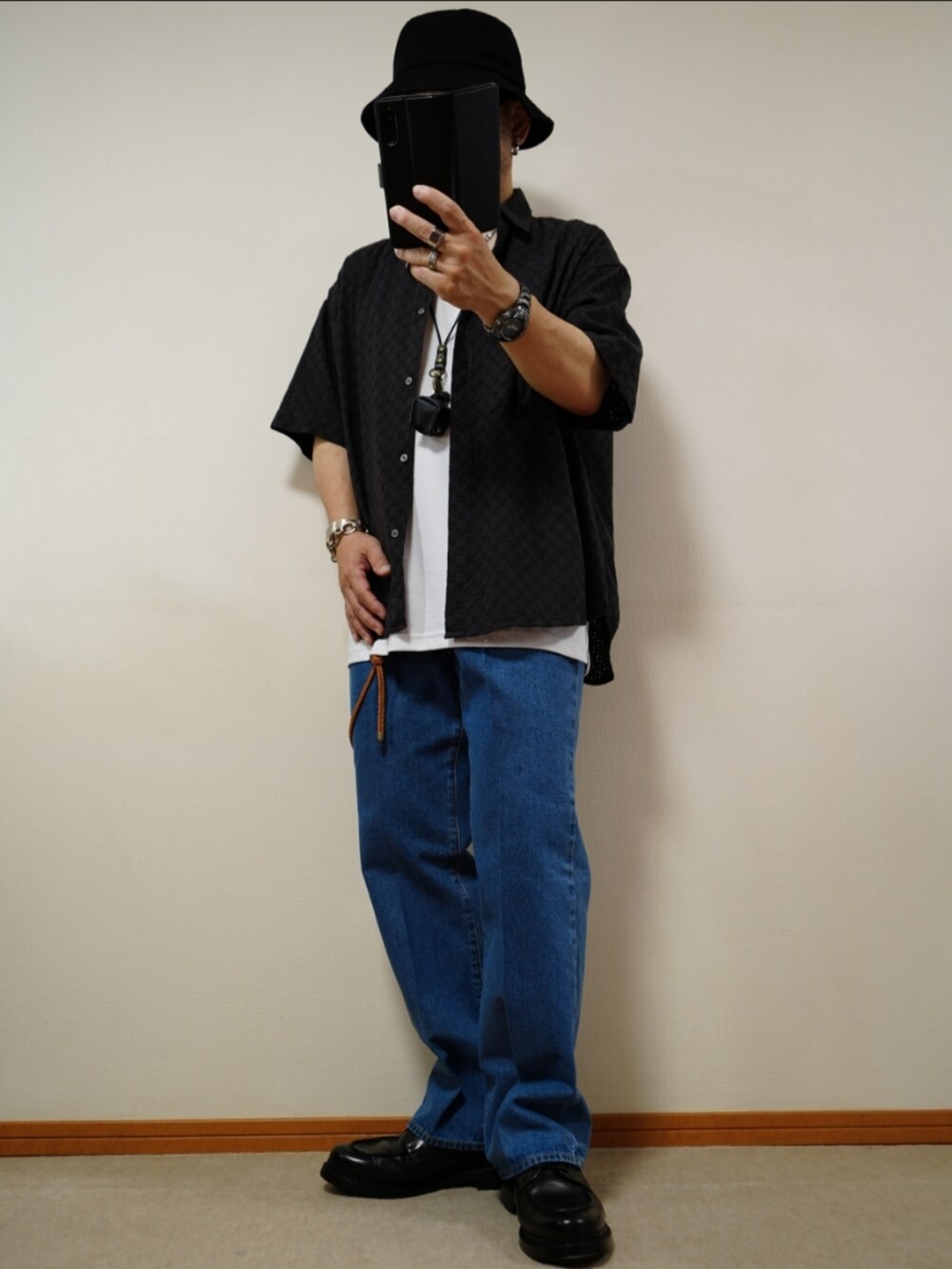 ブラック系のシューズ、ブルー系のデニムパンツ、ホワイト系のタンクトップを着用したメンズの夏コーディネートの2枚目の写真