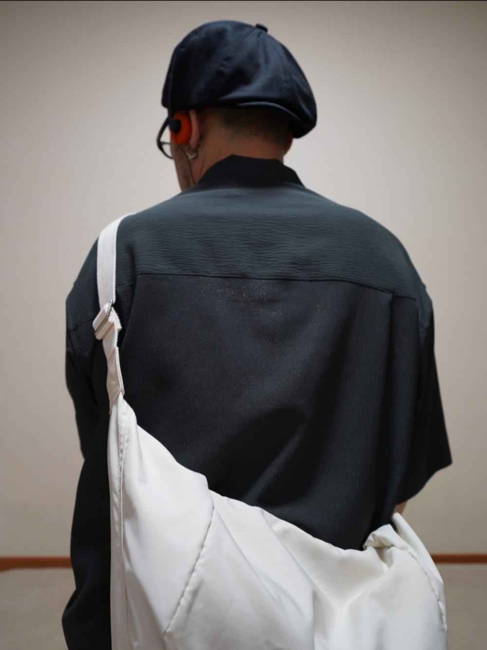 ブラック系のシューズ、ブラウン系のデニムパンツ、グレー系のタンクトップを着用したメンズの夏コーディネートの3枚目の写真