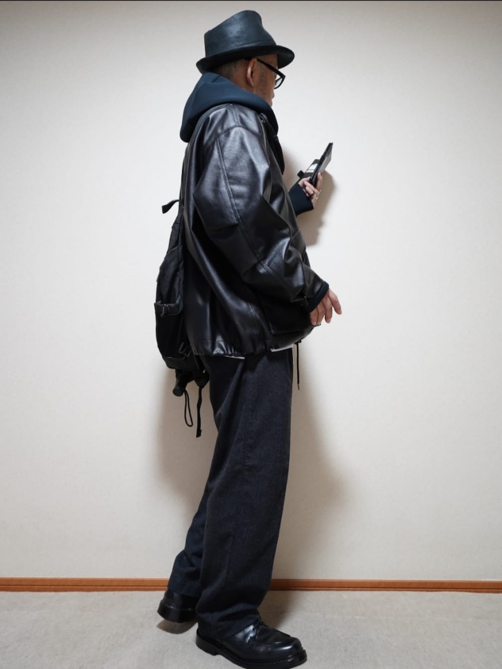 ブラック系のシューズ、グレー系のパンツ、ブラック系のパーカーを着用したメンズの秋コーディネートの4枚目の写真