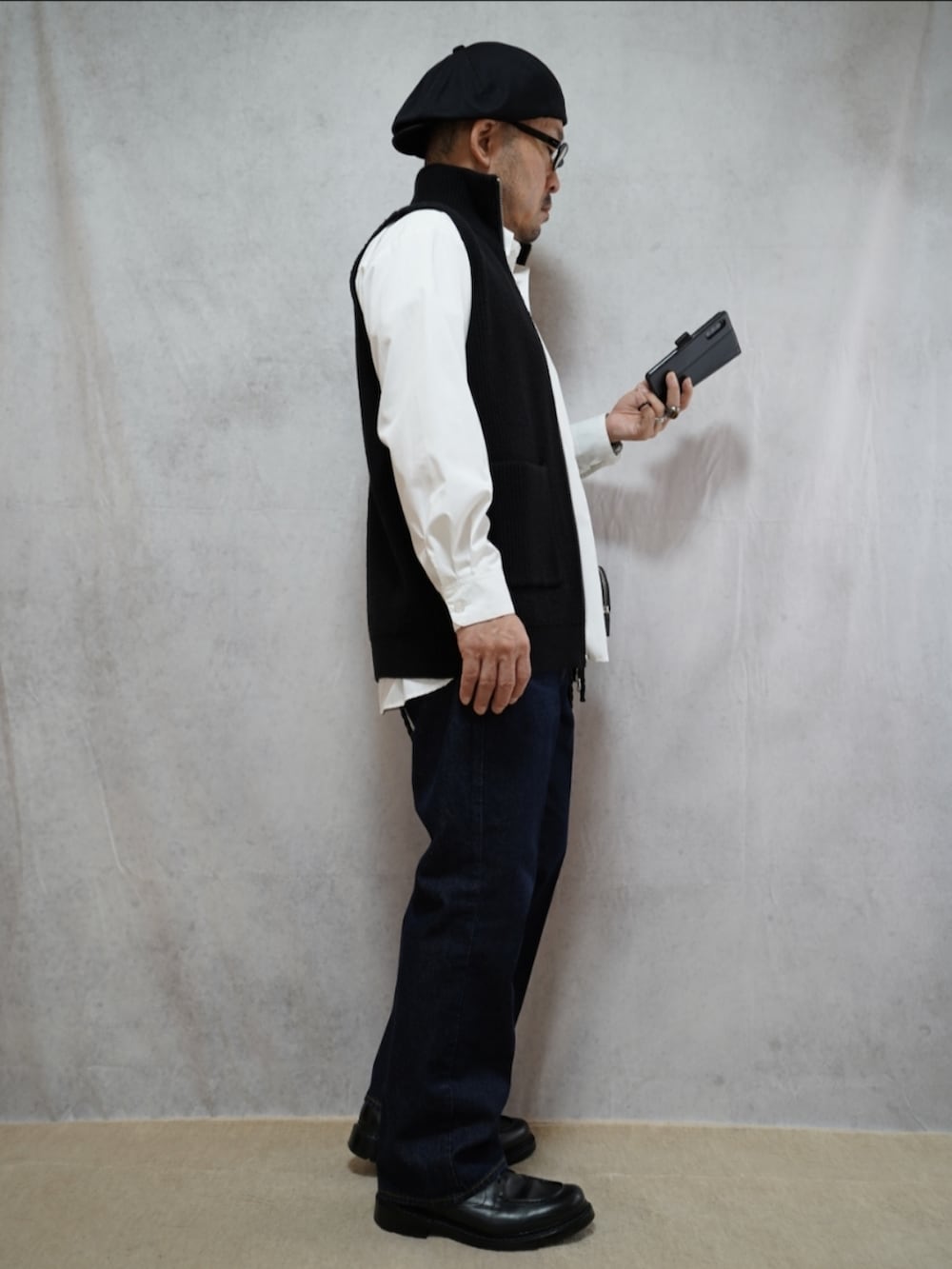 ブラック系のシューズ、ブルー系のデニムパンツ、ブラック系のショルダーバッグを着用したメンズの冬コーディネートの4枚目の写真