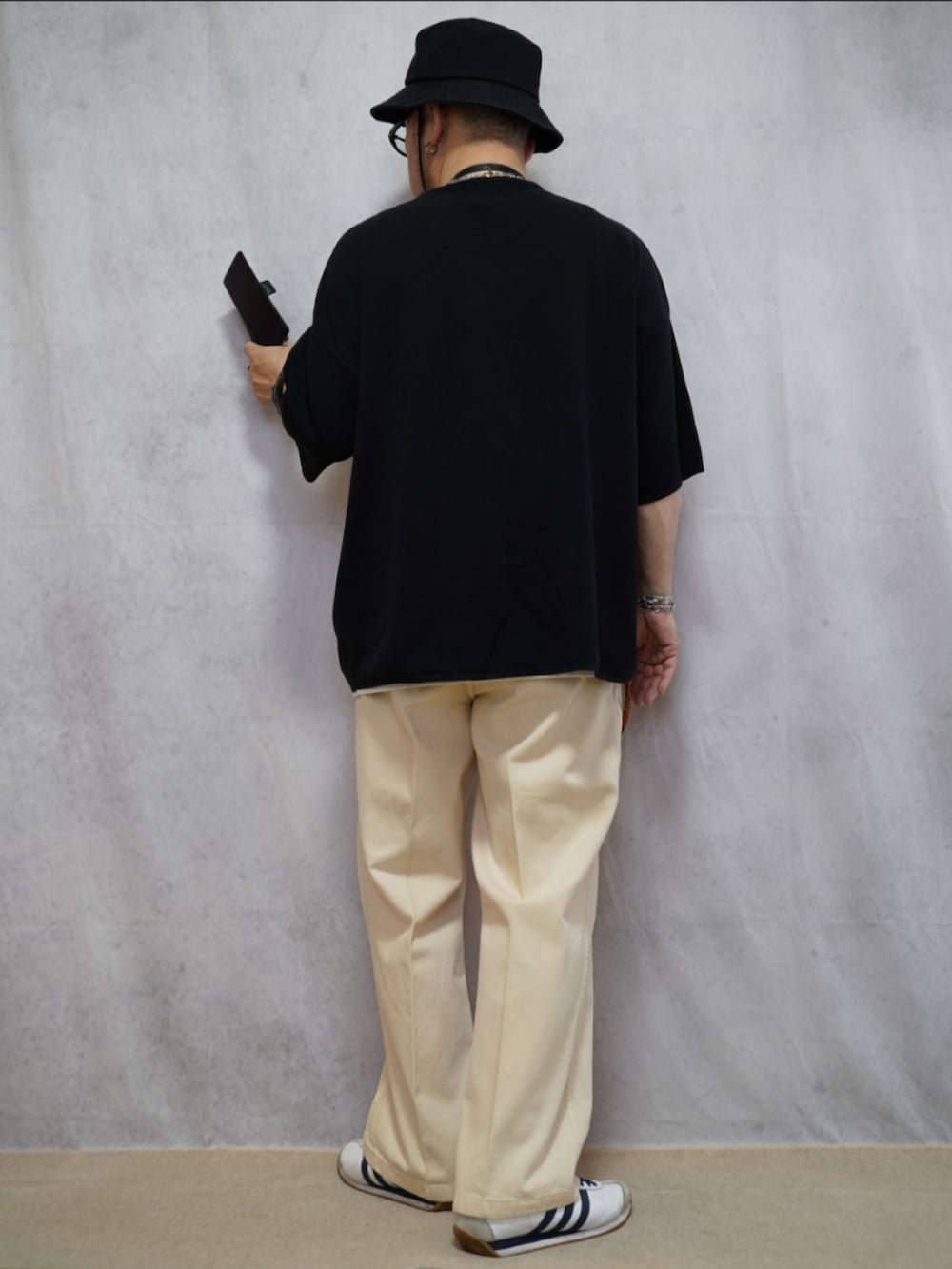 ホワイト系のスニーカー、ホワイト系のデニムパンツ、ブラック系のTシャツ/カットソーを着用したメンズの夏コーディネートの3枚目の写真