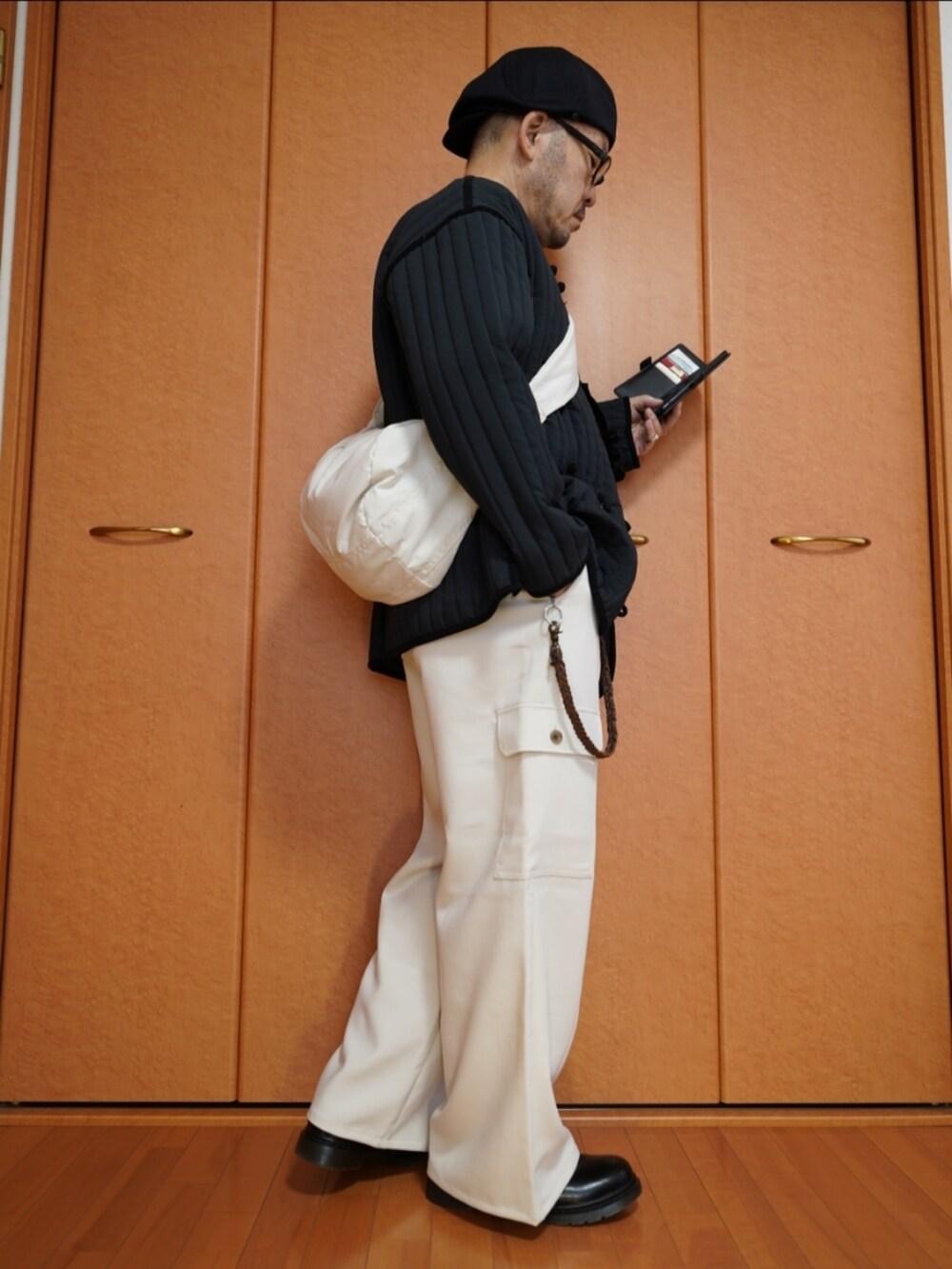 ブラック系のシューズ、グレー系のTシャツ/カットソー、ホワイト系のショルダーバッグを着用したメンズの秋コーディネートの4枚目の写真