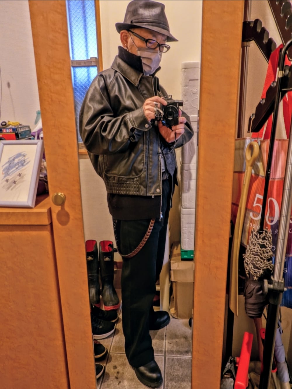 グレー系のデニムパンツ、グレー系のブルゾン、ブルー系のステンカラーコートを着用したメンズの春コーディネートの2枚目の写真