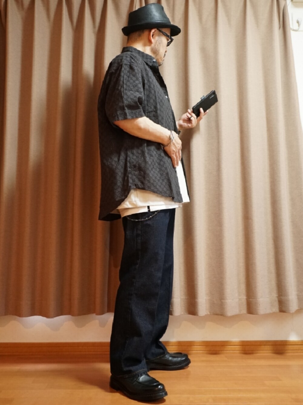 ブラック系のシューズ、ホワイト系のタンクトップ、ブルー系のデニムパンツを着用したメンズの夏コーディネートの4枚目の写真