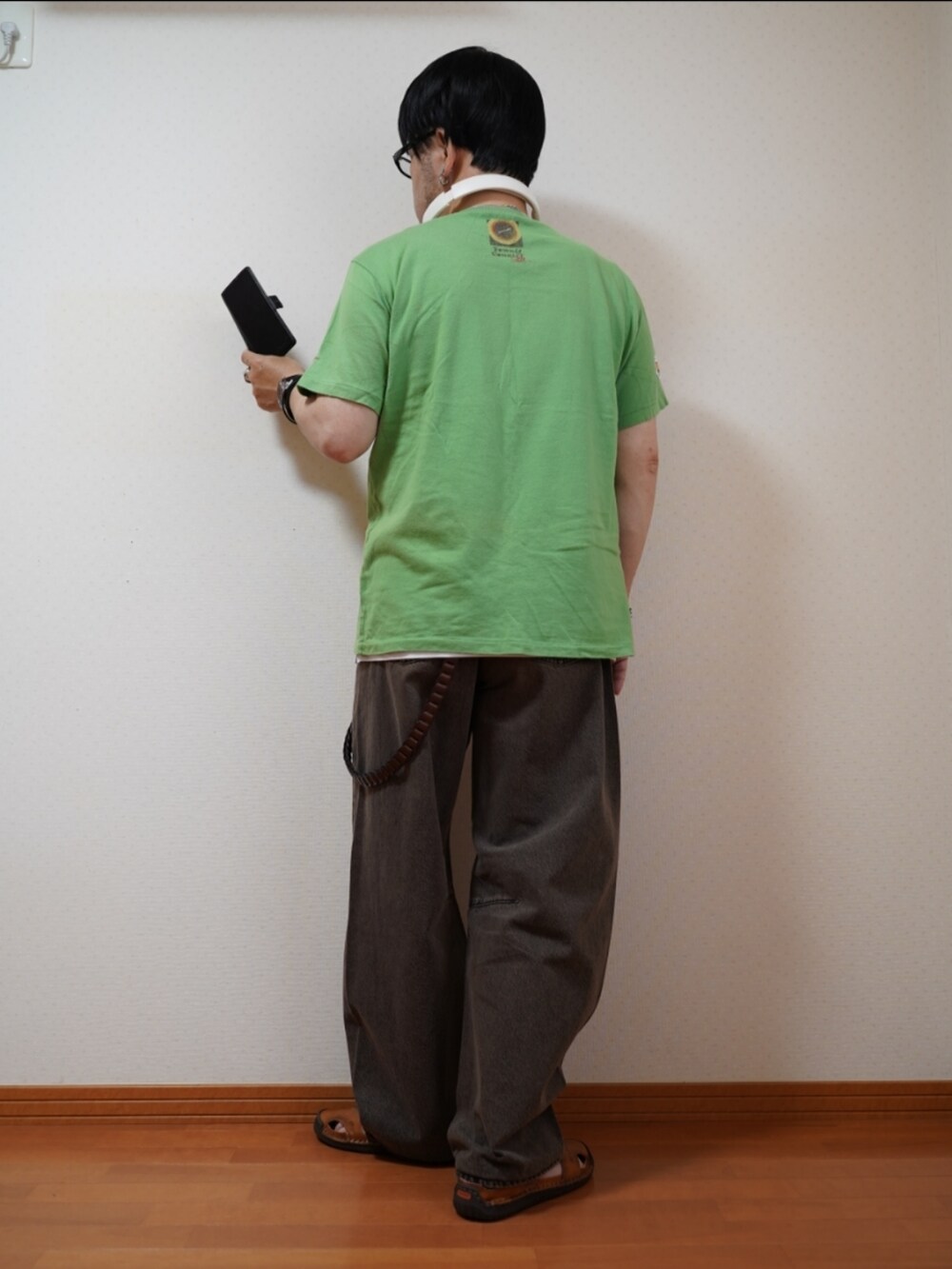ブラック系のサンダル、ブラウン系のデニムパンツ、グリーン系のTシャツ/カットソーを着用したメンズの夏コーディネートの4枚目の写真