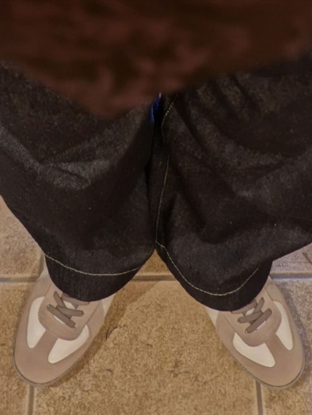 ホワイト系のスニーカー、ブルー系のデニムパンツ、ブラック系のネクタイを着用したメンズの春コーディネートの5枚目の写真