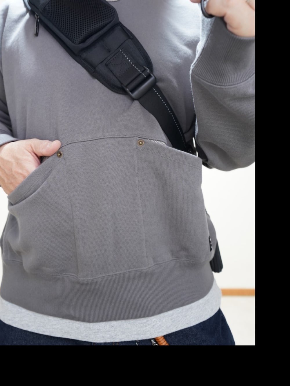 ブラック系のシューズ、ブルー系のデニムパンツ、グレー系のトップスを着用したメンズの春コーディネートの3枚目の写真