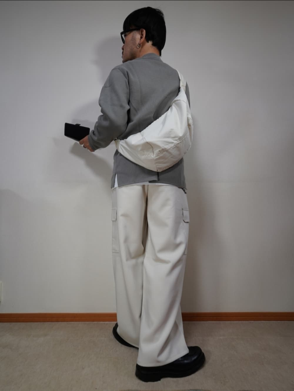 ブラック系のシューズ、ブラウン系のカーゴパンツ、グレー系のニット/セーターを着用したメンズの秋コーディネートの2枚目の写真