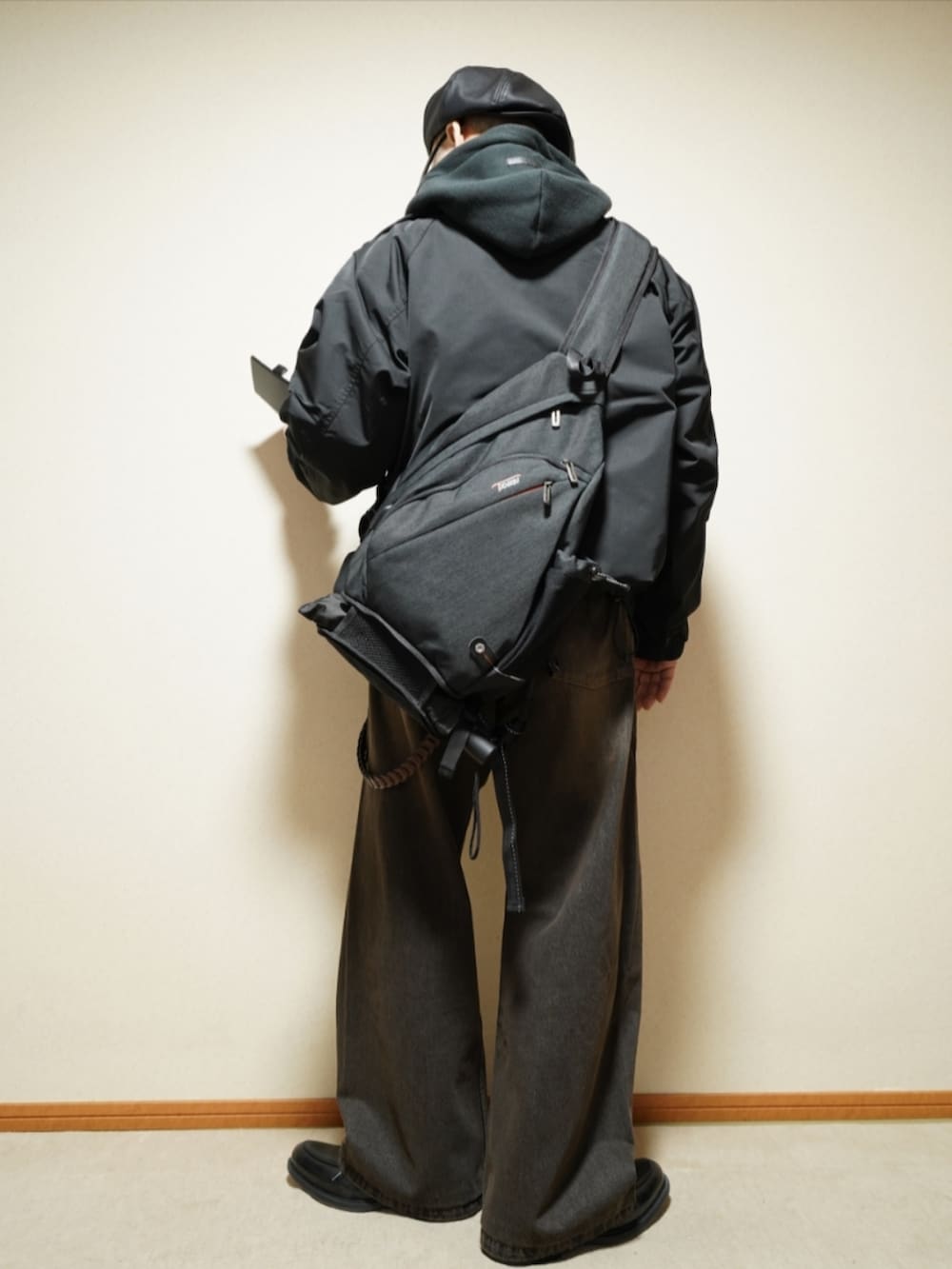 ブラック系のシューズ、ブラック系のデニムパンツ、ブラック系のパーカーを着用したメンズの春コーディネートの3枚目の写真