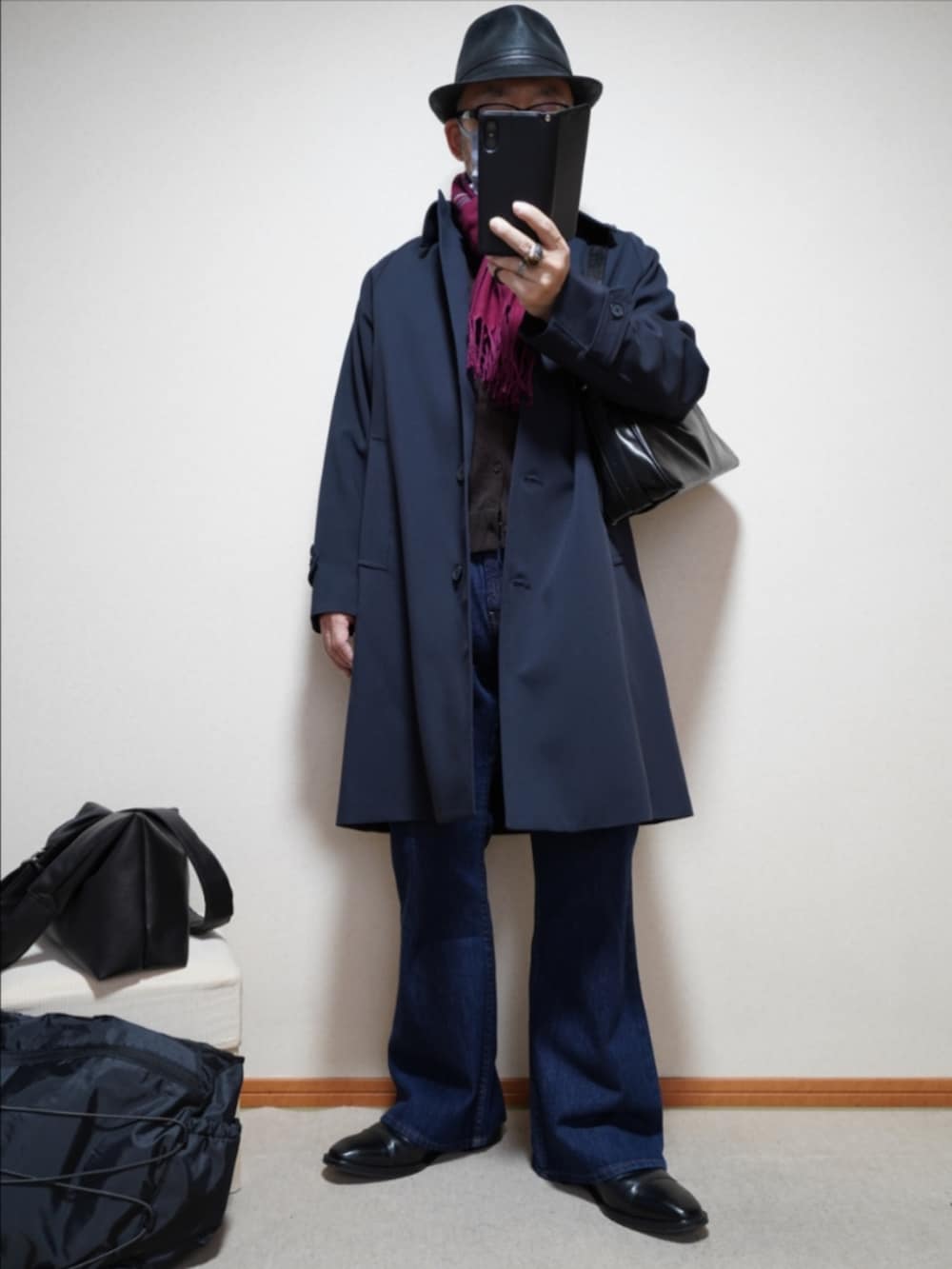 ブラック系のドレスシューズ、ブルー系のデニムパンツ、ブルー系のステンカラーコートを着用したメンズの春コーディネートの2枚目の写真