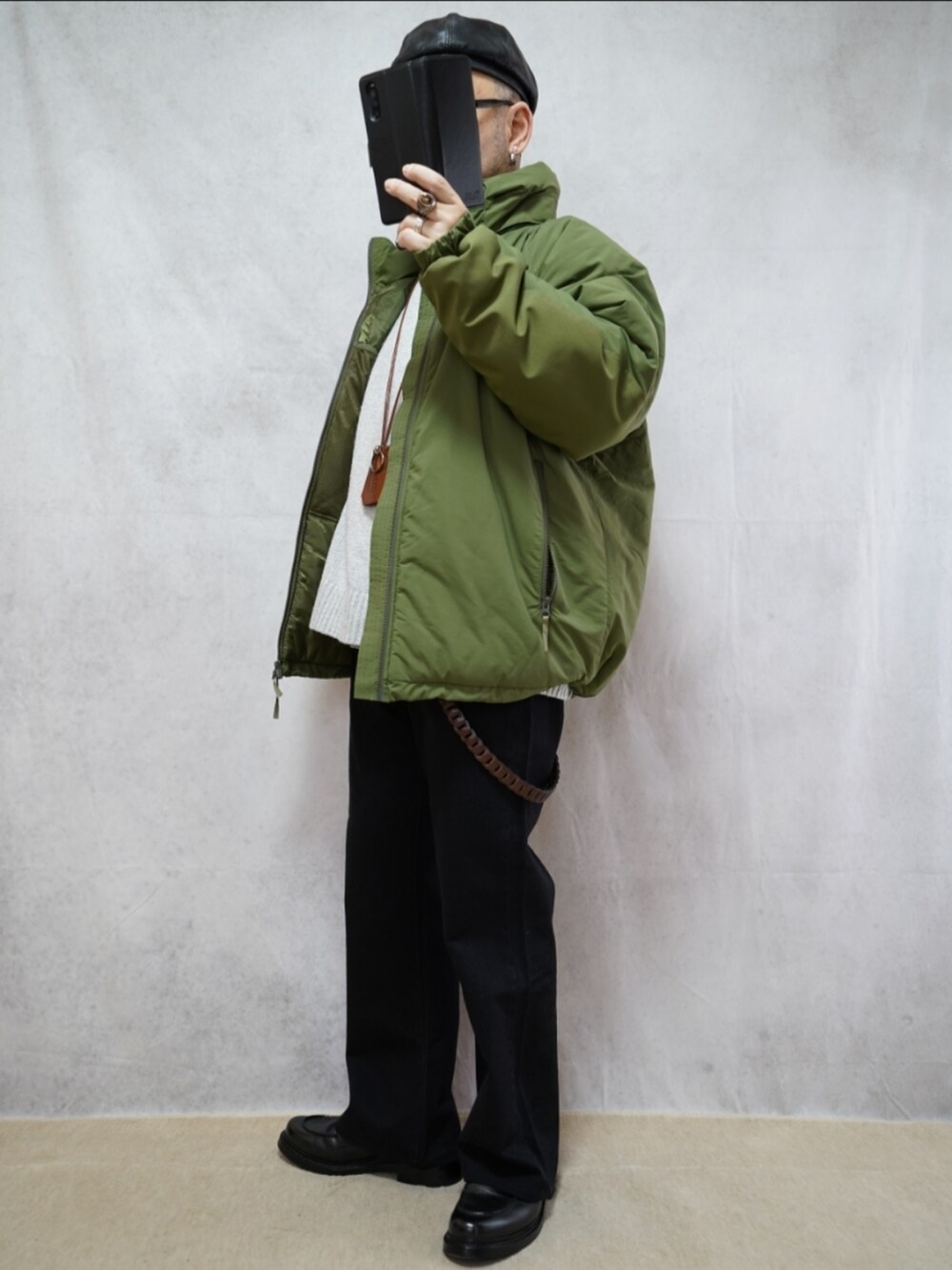 ブラック系のシューズ、グレー系のデニムパンツ、グリーン系のダウンジャケット/コートを着用したメンズの冬コーディネートの2枚目の写真