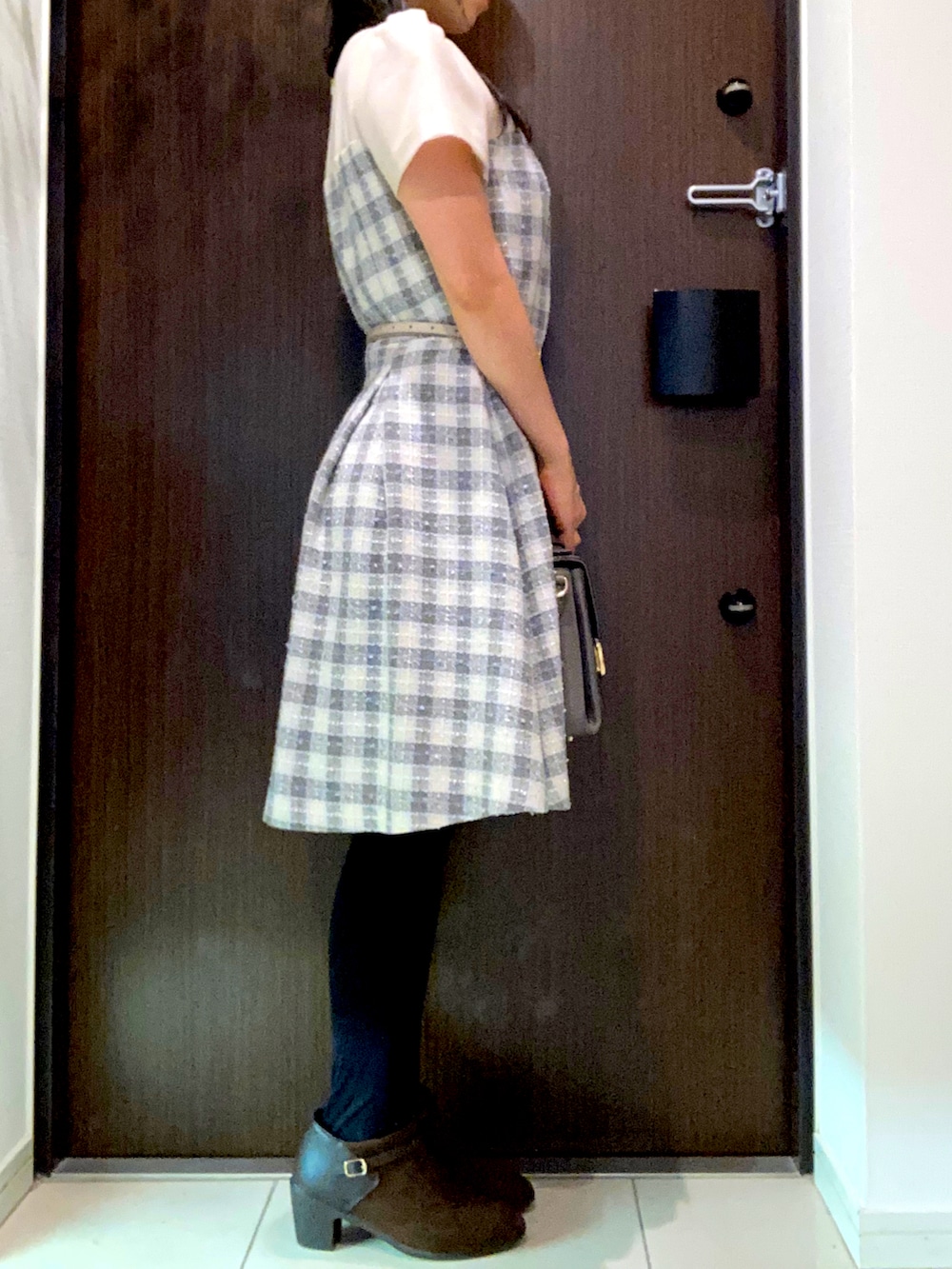 ベージュ系のワンピース、グレー系のハンドバッグ、ブラウン系のブーティを着用したレディースの秋コーディネートの2枚目の写真