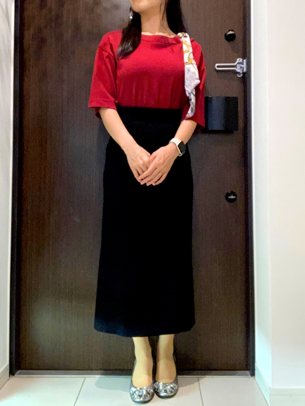 レッド系のTシャツ/カットソー、ブラック系のスカート、シルバー系のパンプスを着用したレディースの秋コーディネートの2枚目の写真