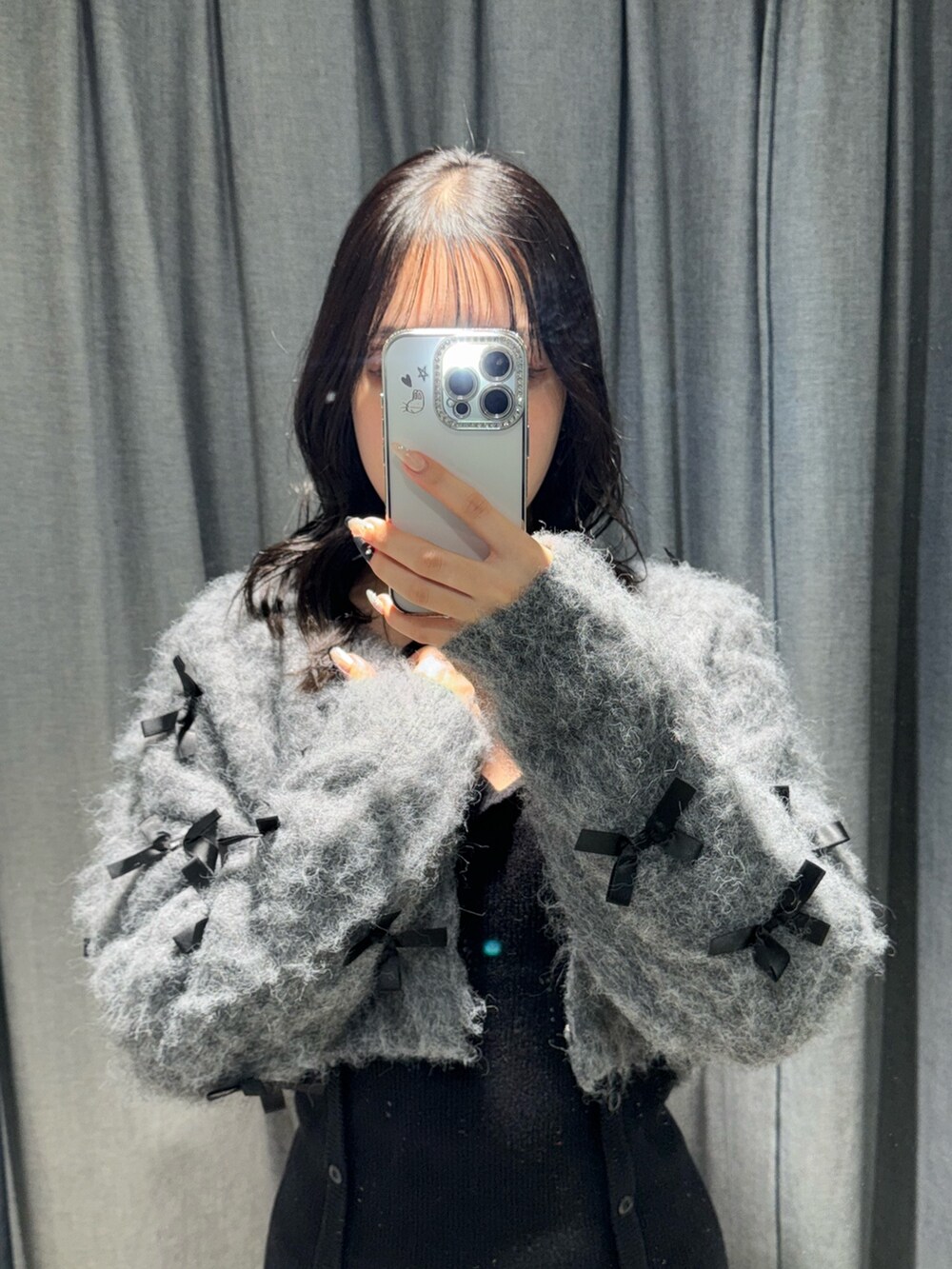 ブラック系のワンピース、グレー系のカーディガン/ボレロ、ブラック系のブーツを着用したレディースの冬コーディネートの2枚目の写真
