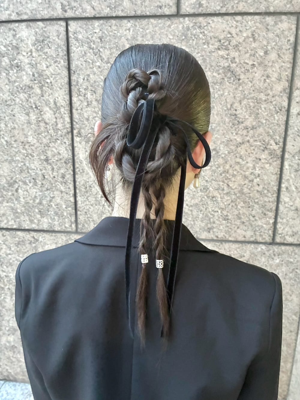 グレー系のパンツドレス、ブラック系のテーラードジャケット、シルバー系のパンプスを着用したレディースの春コーディネートの2枚目の写真