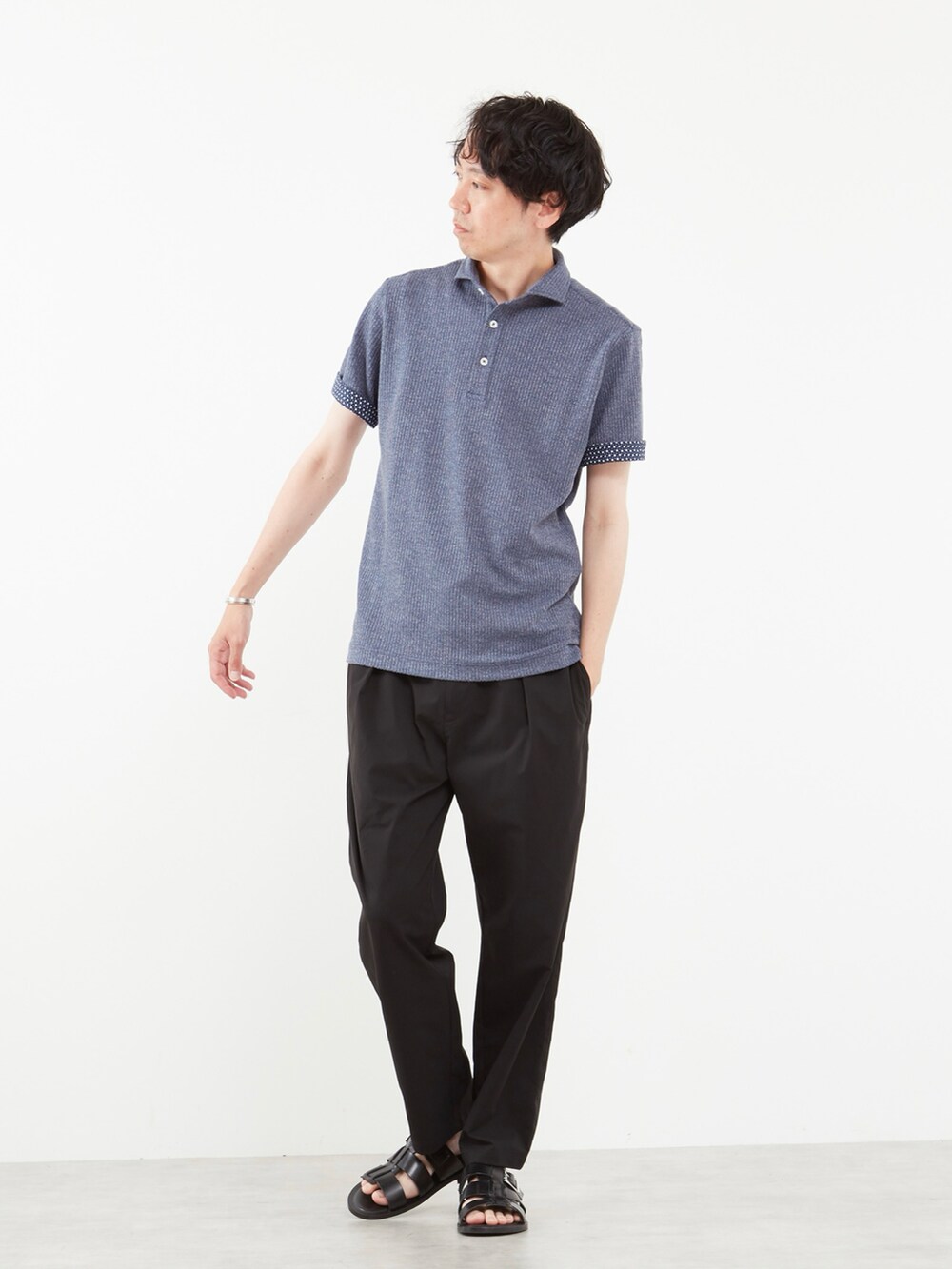 ブルー系のポロシャツ、ブラック系のサンダルを着用したメンズの春コーディネートの2枚目の写真