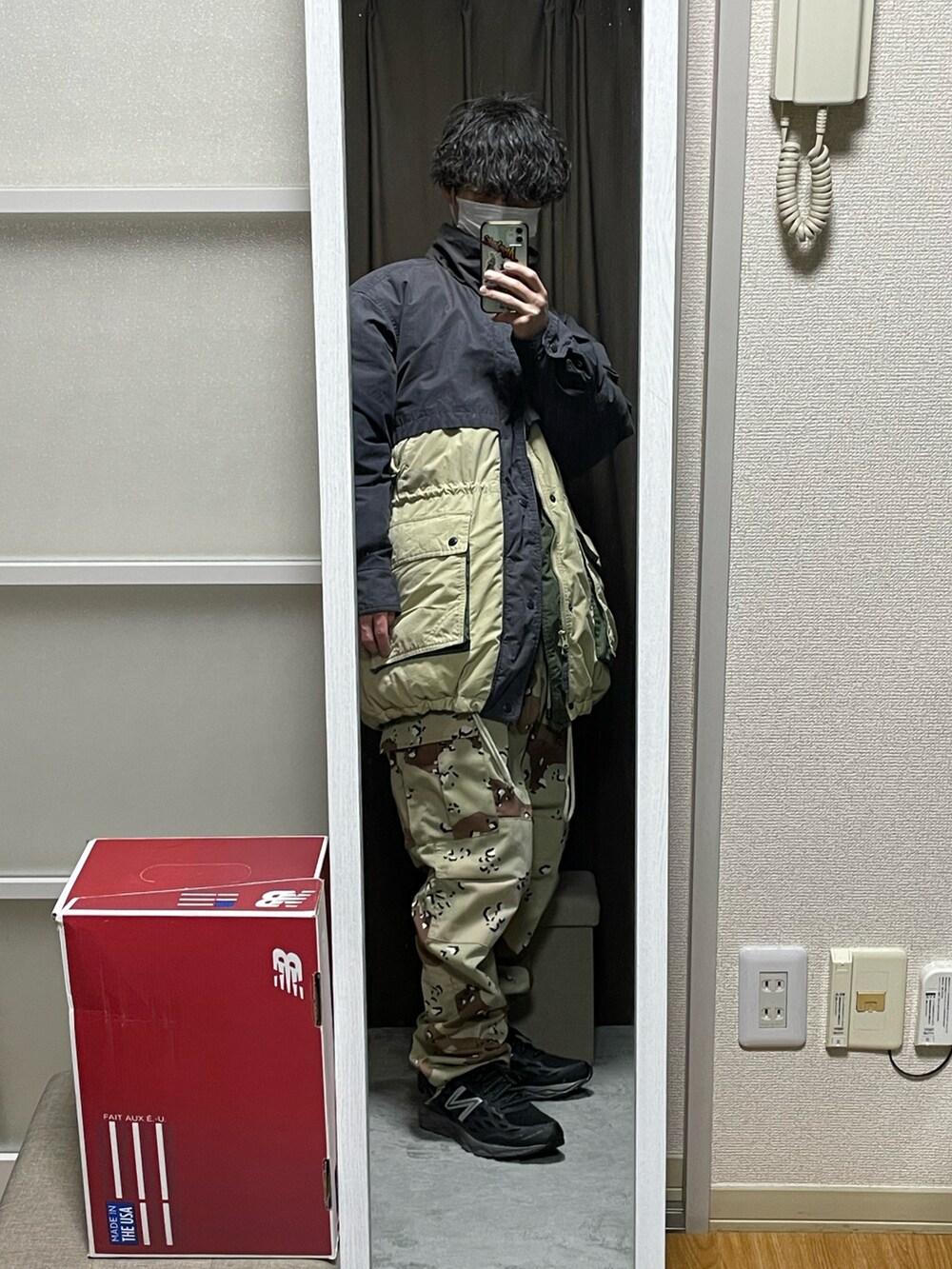 ゴールド系のダウンベスト、ベージュ系のカーゴパンツ、ブラック系のスニーカーを着用したメンズの冬コーディネートの3枚目の写真