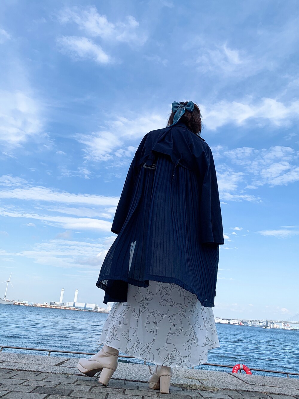 ホワイト系のスカート、ベージュ系のブーツ、ブラウン系のショルダーバッグを着用したレディースの冬コーディネートの2枚目の写真