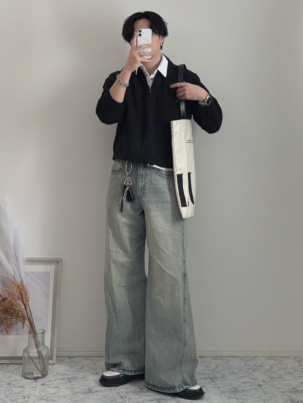 ブラック系のローファー、ブルー系のデニムパンツ、ホワイト系のトートバッグを着用したメンズの春コーディネートの2枚目の写真